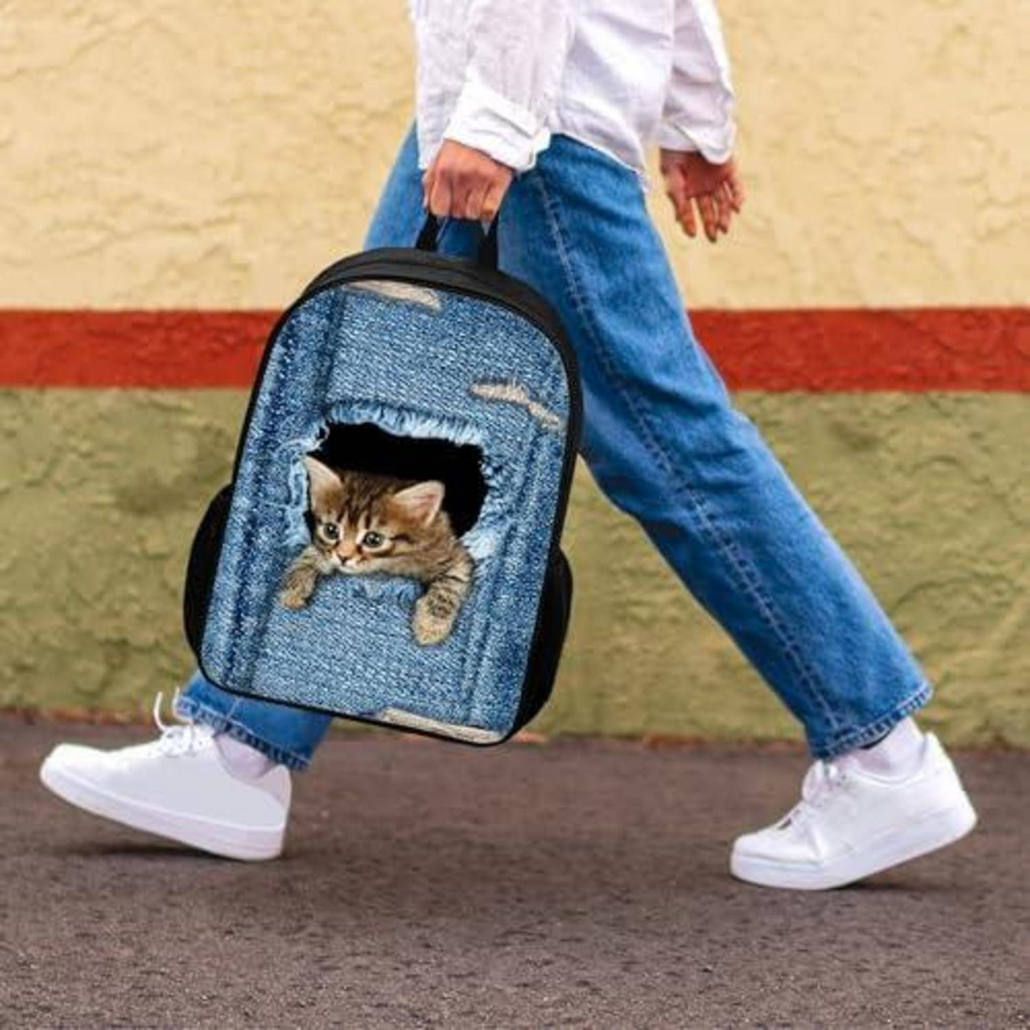 Eine Person, die mit einem blauen Haustierrucksack läuft, aus dessen vorderer Öffnung ein Kätzchen herausschaut.