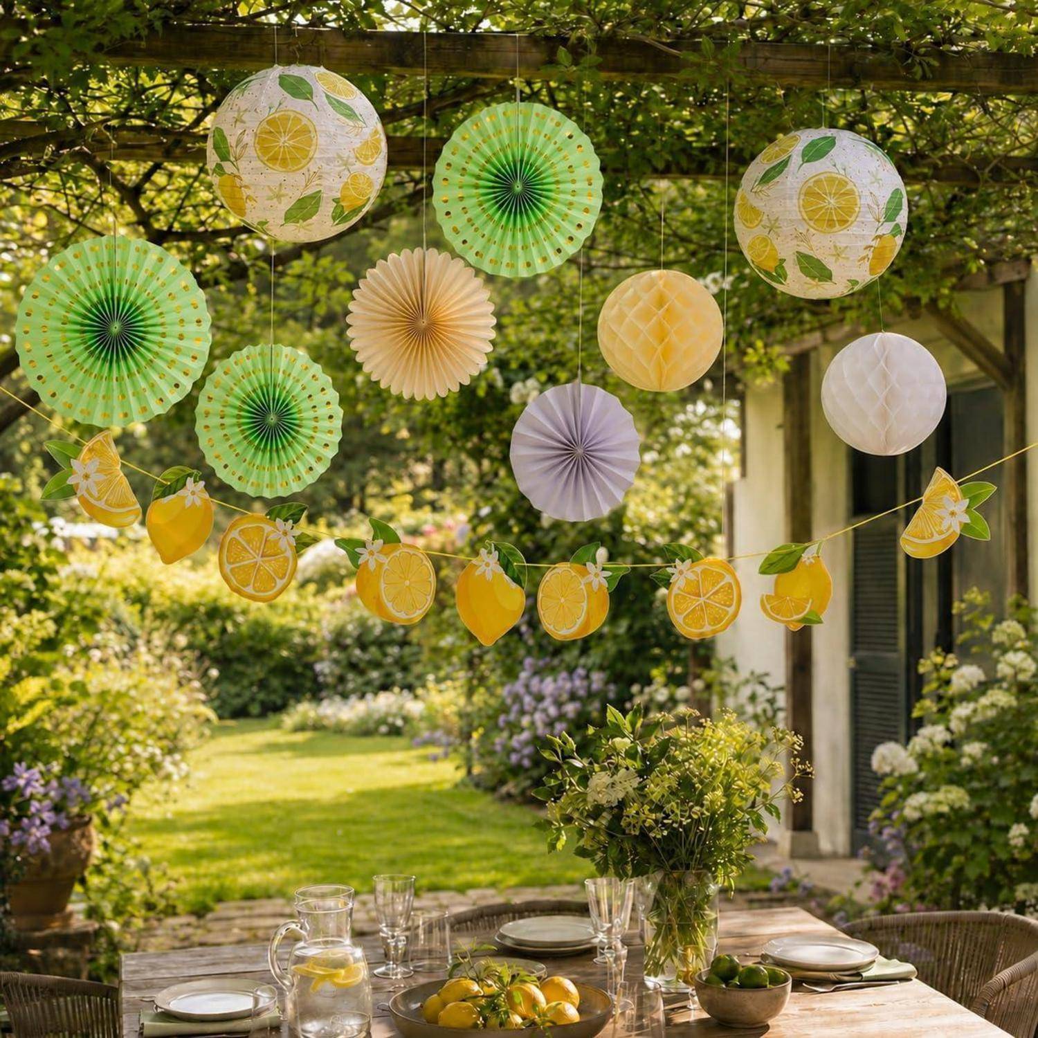 Gartenparty-Setup im Freien mit farbenfrohen hängenden Papierlaternen und Zitronengirlanden über einem eingedeckten Esstisch in einem üppigen Hinterhof.