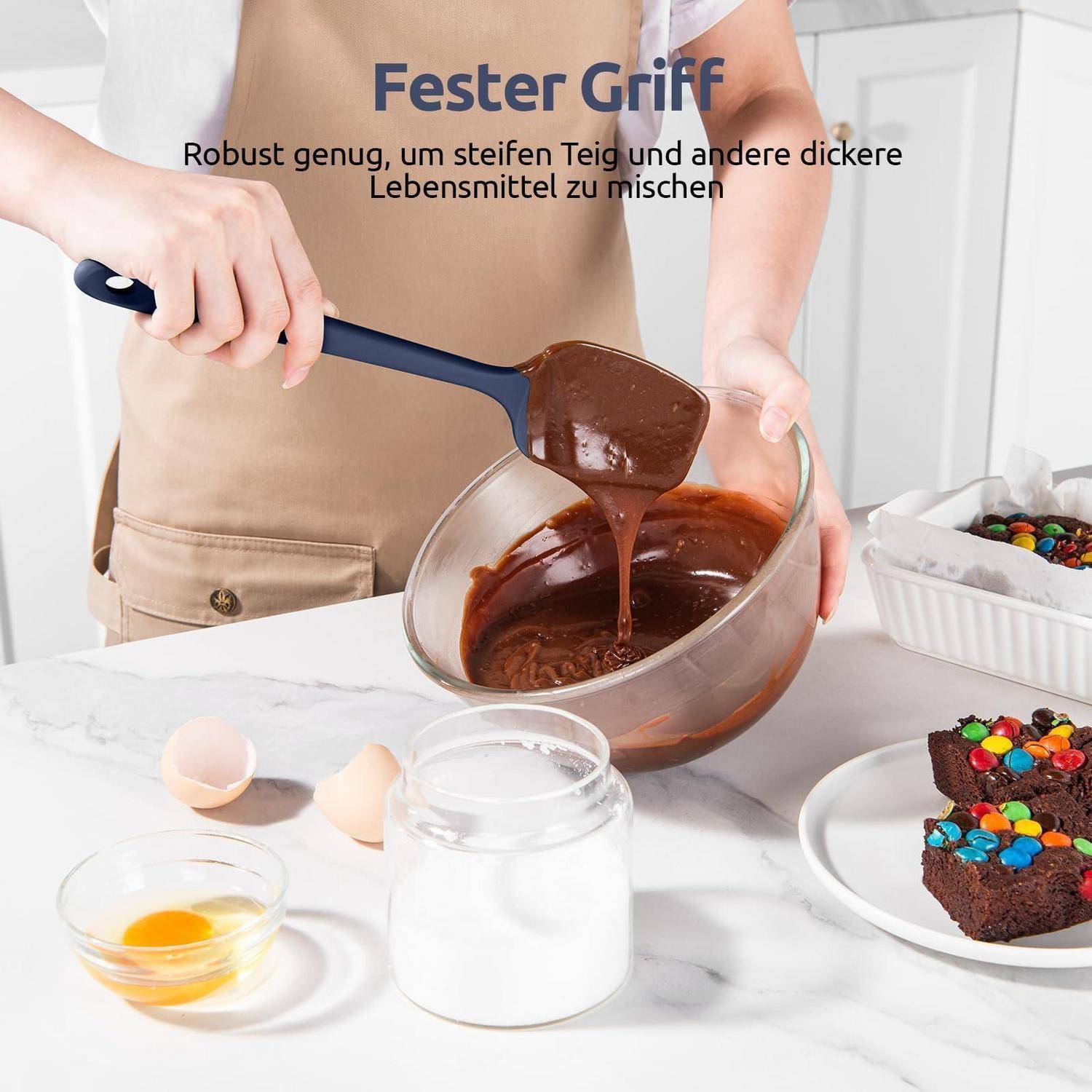 Person, die dickflüssigen Schokoladenteig in einer Schüssel mit einem robusten Spatel mischt; deutscher Text lautet „Fester Griff