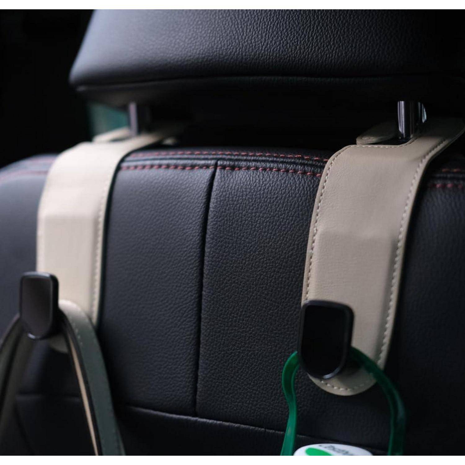 Nahaufnahme einer schwarzen Autositzrückenlehne aus Leder mit zwei beige Hängeschlaufen und Befestigungsclips.
