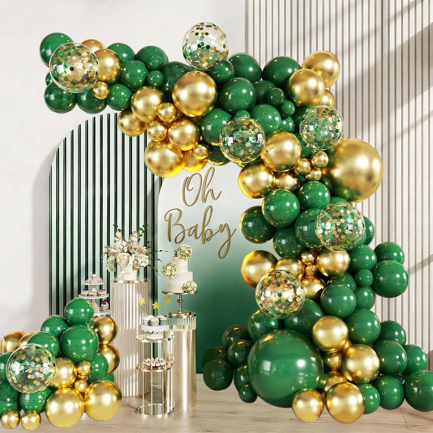 Grüner und goldener Babyparty-Hintergrund mit Ballonbogen, 'Oh Baby'-Schild und Kuchenanzeigetischen.