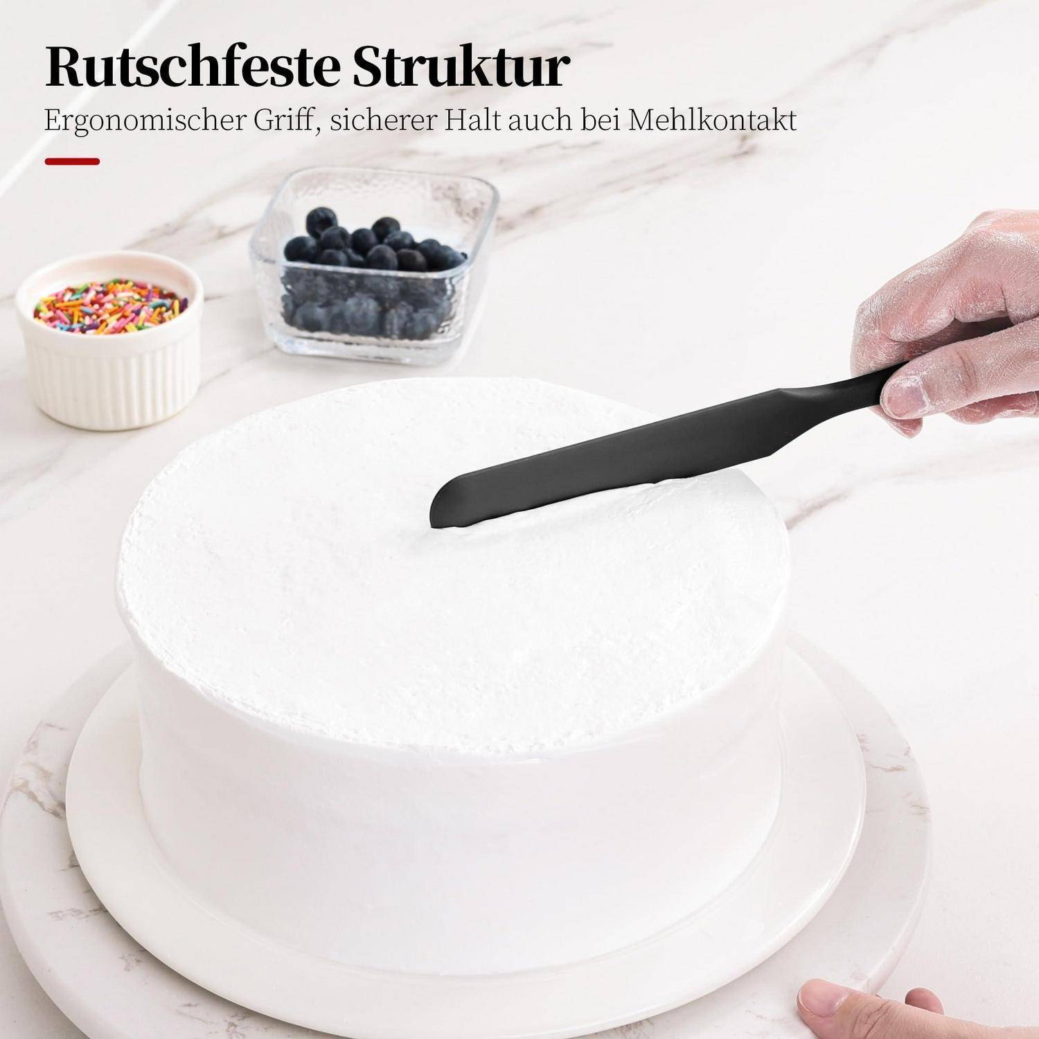 Hand, die einen schwarzen Offset-Spatel über einem weiß glasierten Kuchen hält; deutscher Text besagt „Rutschfeste Struktur