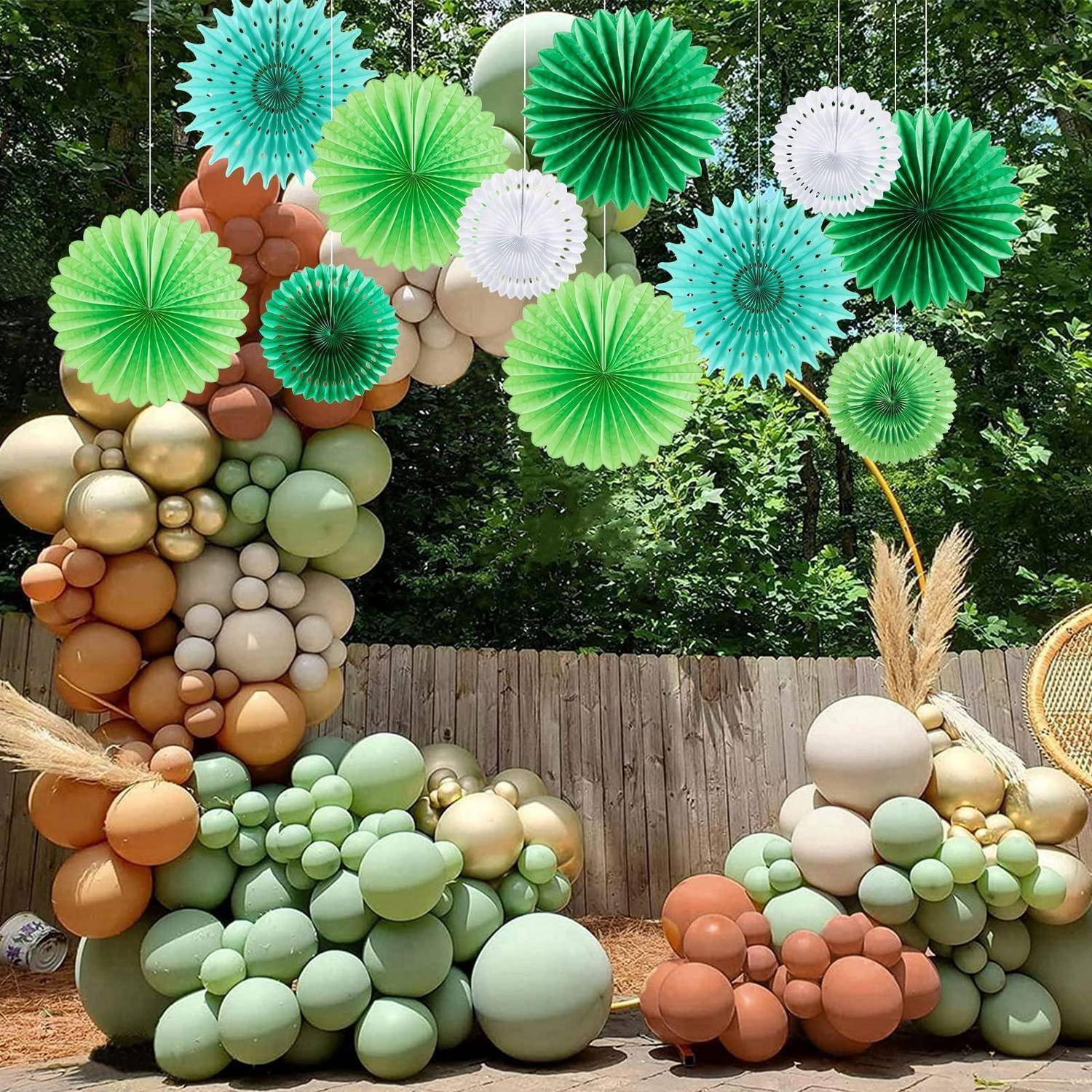 Outdoor-Ballonbogen und wolkenähnliche Ballonskulpturen in Grün, Gold, Creme und Terrakotta, dekoriert mit hängenden Papierfächern.