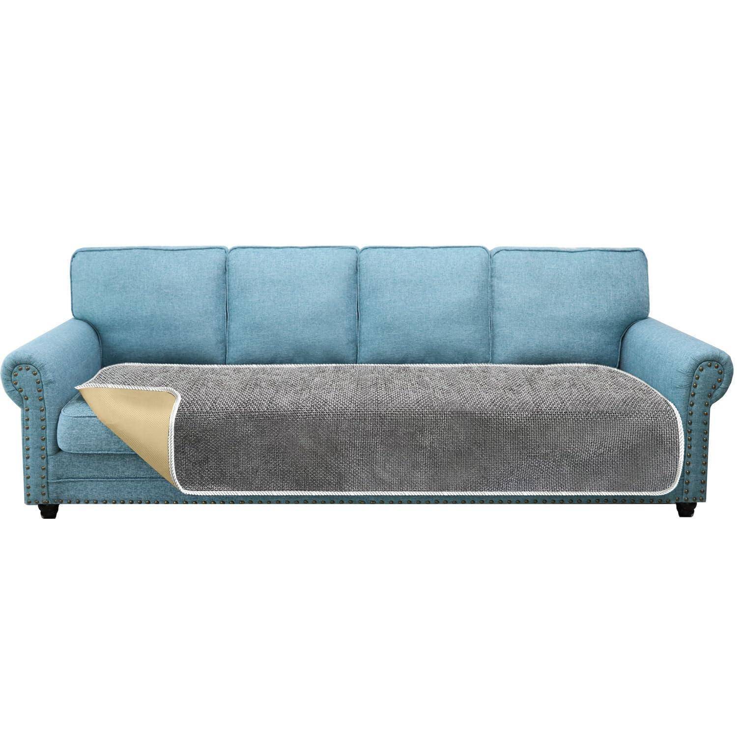Blaues Dreisitzer-Sofa mit einer grau-und-beige farbigen Husse über dem Sitzbereich, vor einem weißen Hintergrund dargestellt.