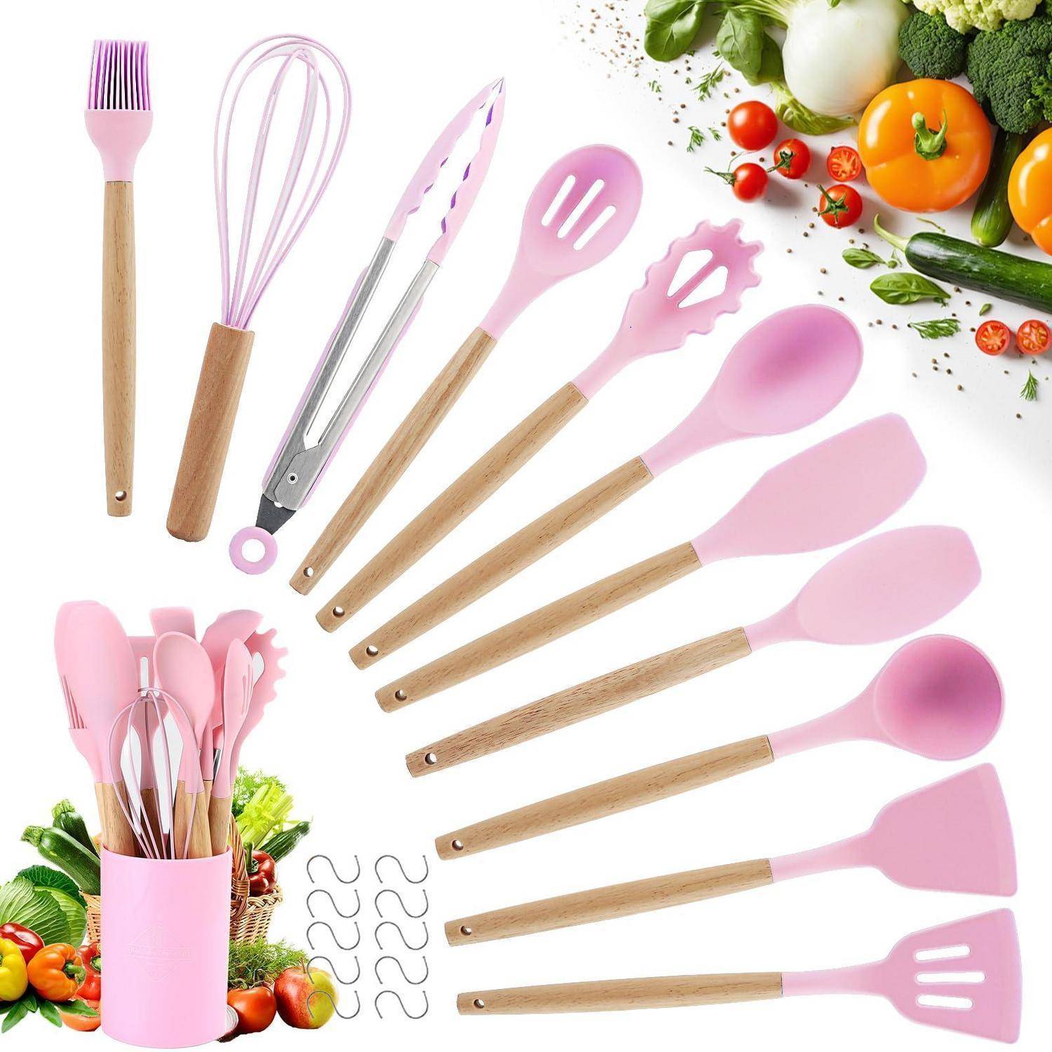 Rosa Silikon- und Holz-Küchenutensilien-Set, bestehend aus Schneebesen, Spachteln, Löffel, Zange, Bürste und Sieblöffeln, mit Gemüse, das drumherum angeordnet ist.