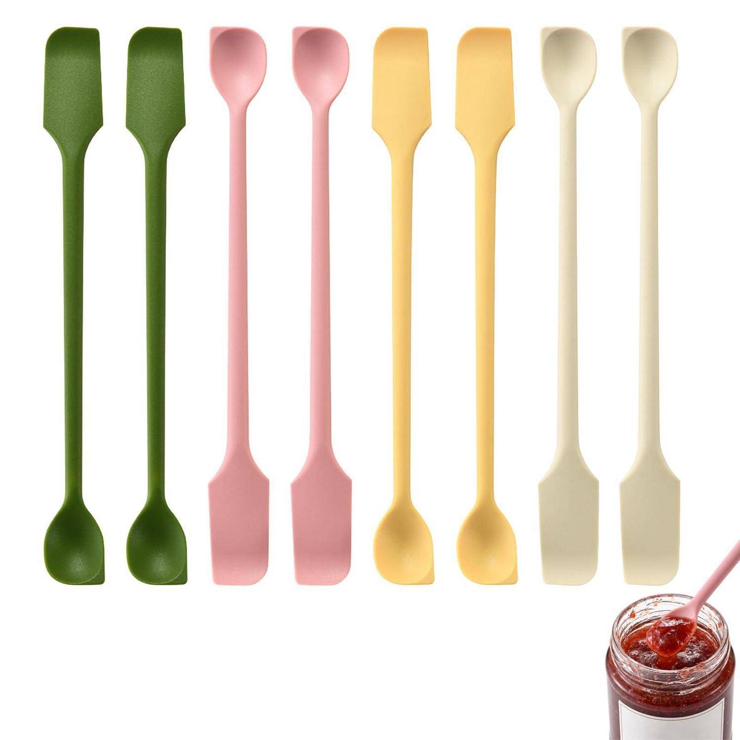 Acht farbenfrohe zweiseitige Spachteln oder Spachtelmesser, in Reihen über einem Glas mit roter Marmelade angeordnet, mit einem passenden Utensil auf weißem Hintergrund.