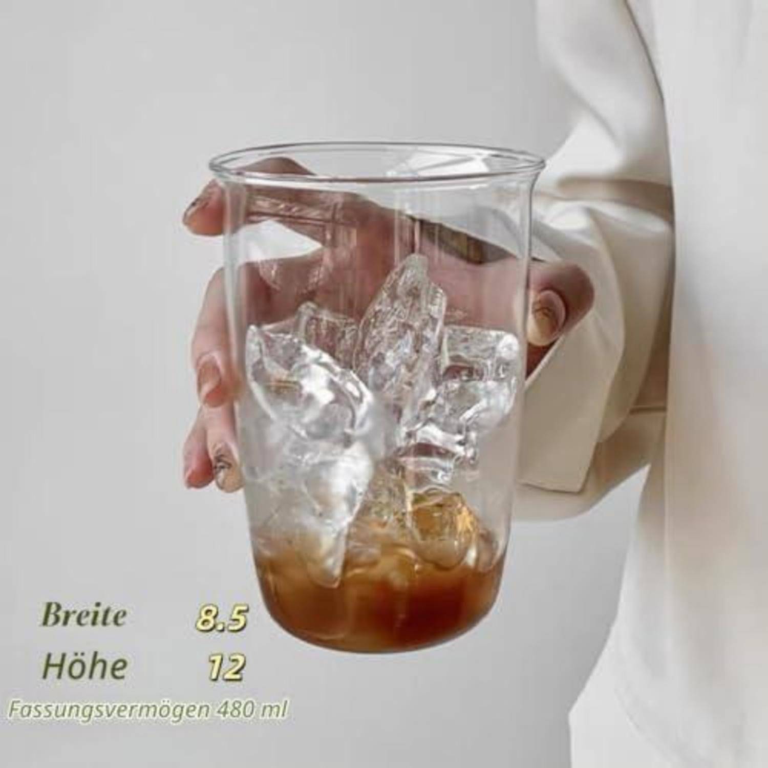 Glastumbler in einer Hand gehalten, teilweise gefüllt mit Eis und brauner Flüssigkeit; Text vermerkt 'Breite 8,5', 'Höhe 12' und Fassungsvermögen 480 ml.