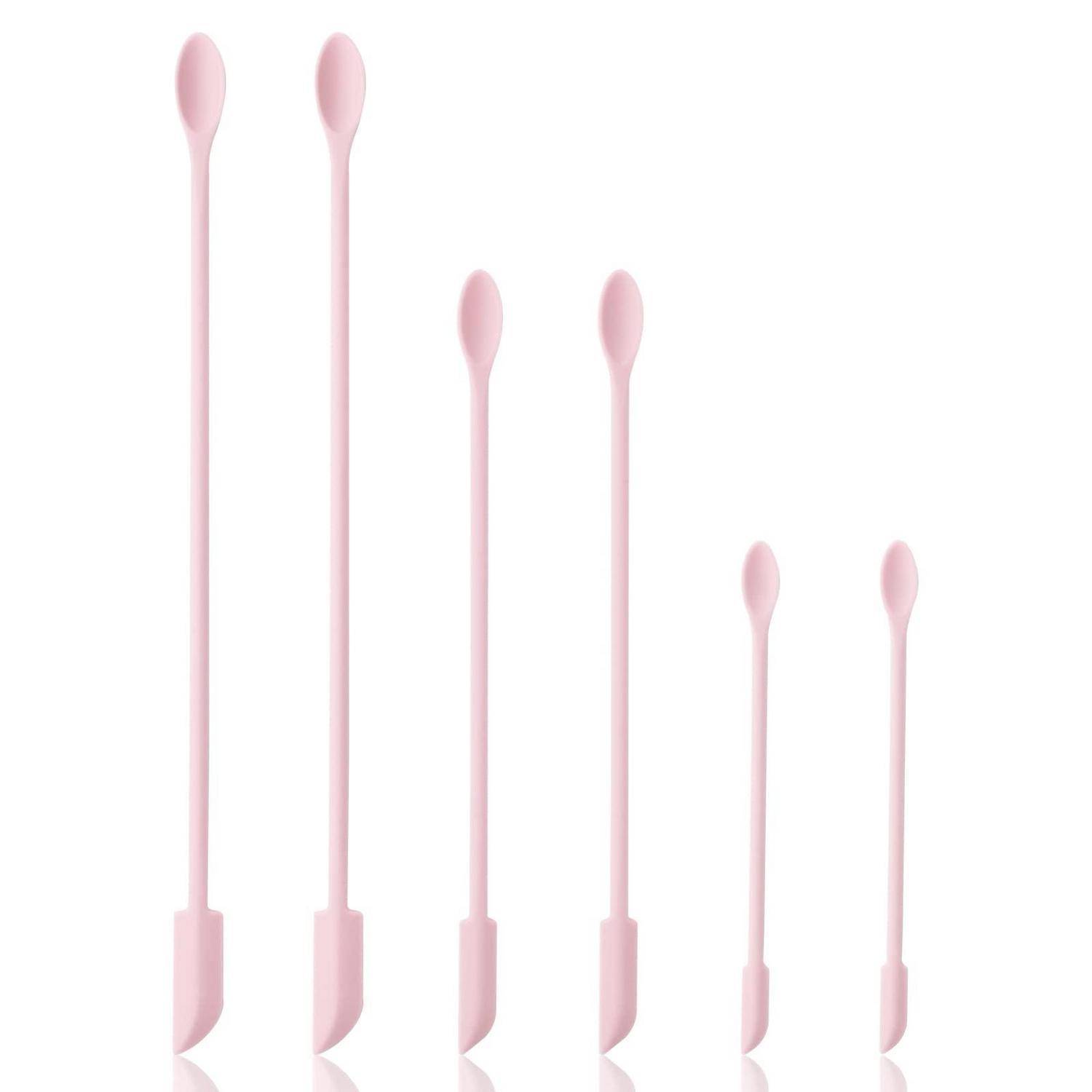 Sechs rosa Wattestäbchen unterschiedlicher Länge auf weißem Hintergrund angeordnet.