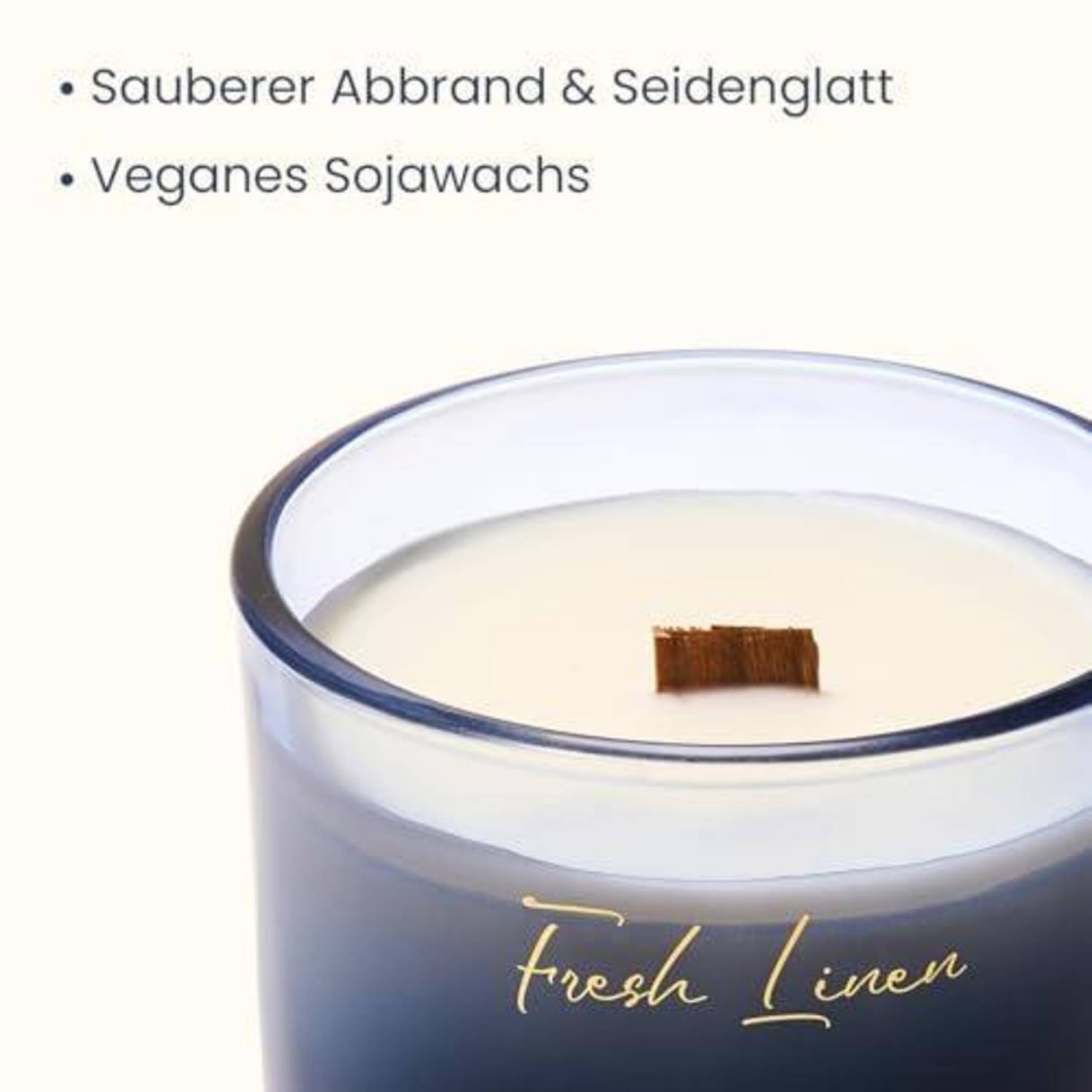 Eine duftende Kerze in einem mattiertem Glasgefäß mit der Aufschrift „Fresh Linen
