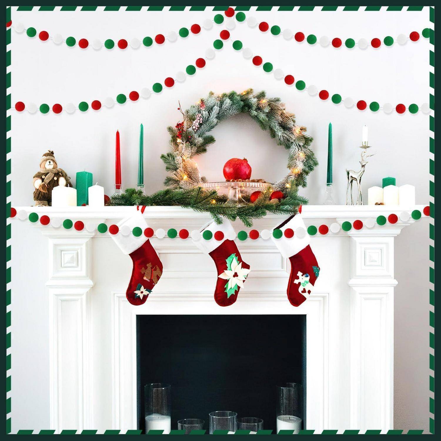 Ein weißer Kaminsims, weihnachtlich dekoriert mit rot-grünen Girlanden, einem Kranz, Strümpfen, Kerzen und Weihnachtsfiguren.