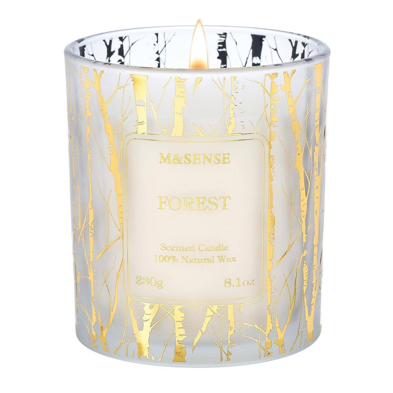 Weiße duftende Kerze in einem Glaskrug mit goldenem Birkenmuster und „FOREST