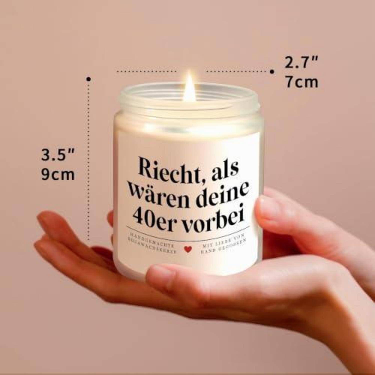 Brennende Kerze in einem Glaskrug, der in zwei Händen gehalten wird, beschriftet auf Deutsch „Riecht, als wären deine 40er vorbei", mit Größenmarkierungen 3,5"" und 2,7"