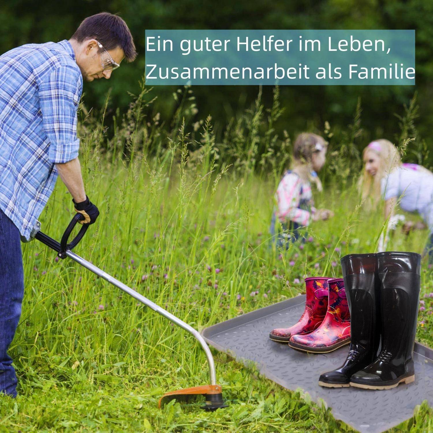 Ein Mann mäht Gras neben einer Matte mit Regenstiefeln; im Hintergrund spielen zwei Kinder und der deutsche Text lautet „Ein guter Helfer im Leben, Zusammenarbeit als Familie".