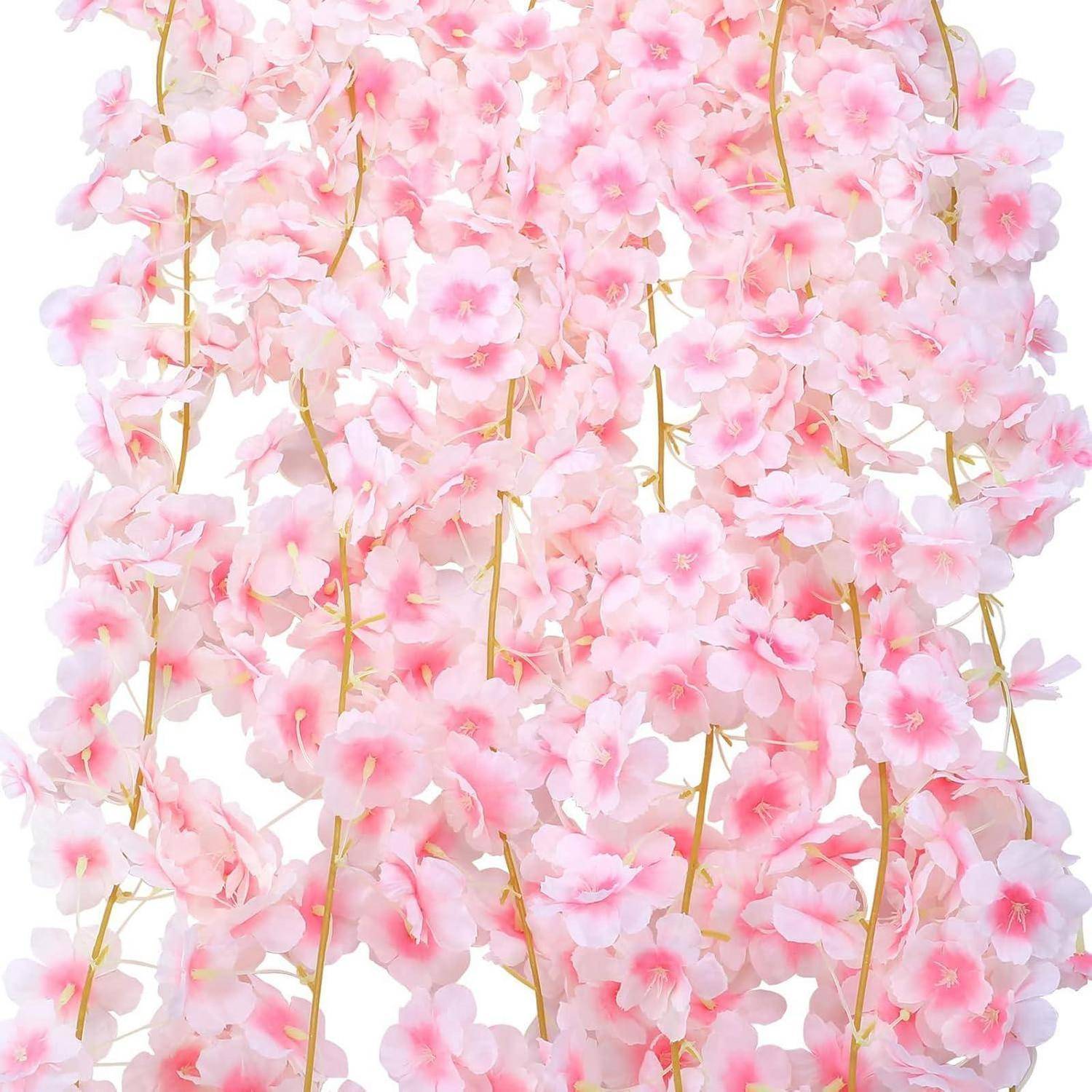 Traube von zarten rosa Kirschblüten auf dünnen Goldzweigen vor weißem Hintergrund.