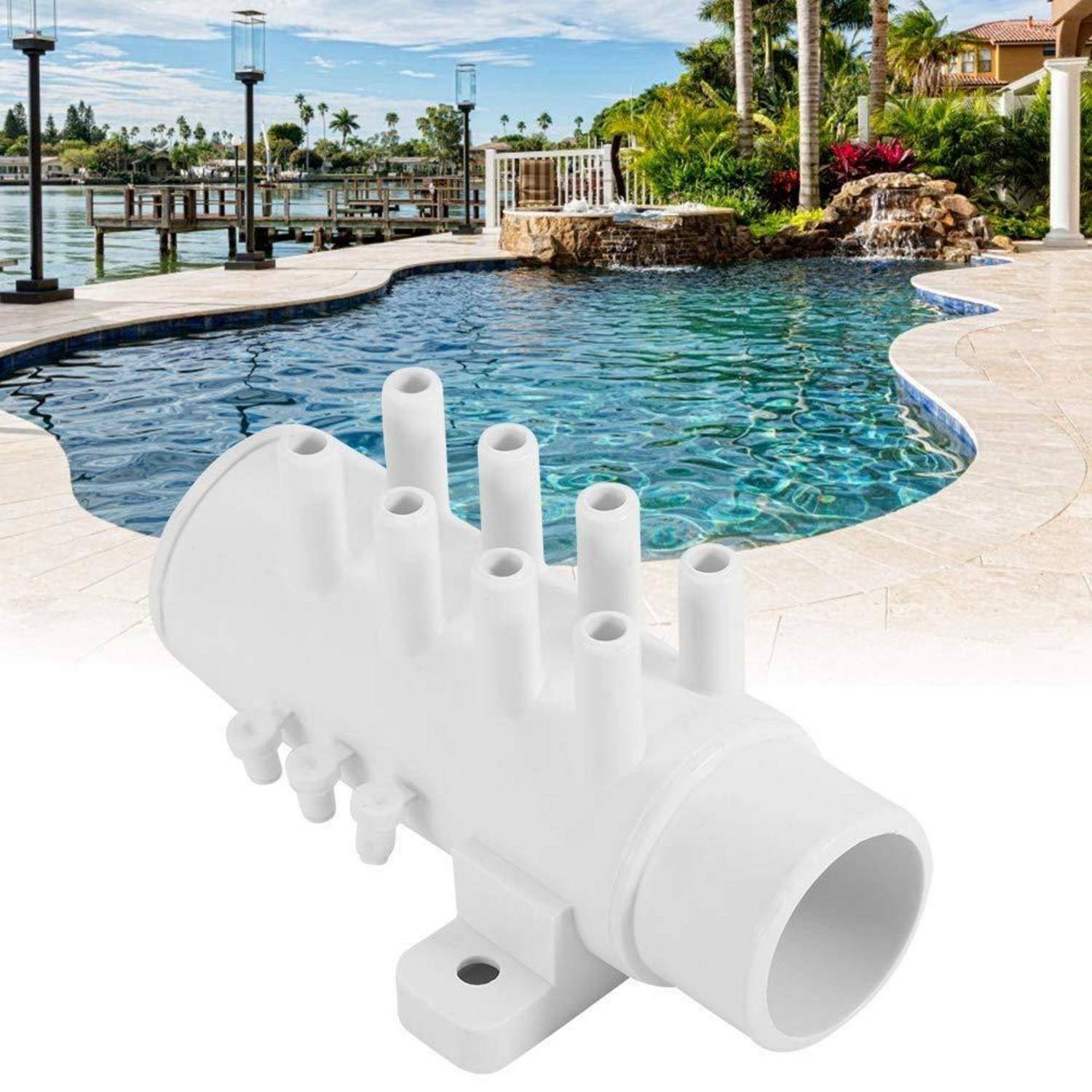Weißes Kunststoff-Rücklauf-Düsenfitting, das vor einem Swimmingpool im Garten und einer Terrasse gezeigt wird.