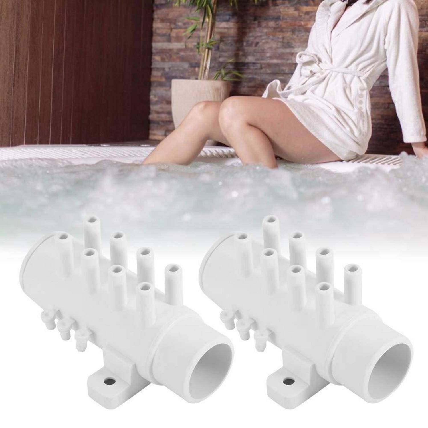 Zwei weiße Kunststoff-Hydrotherapie-Badewellenfittings, die vor einer Frau gezeigt werden, die sich in einer Whirlpool-Badewanne entspannt.