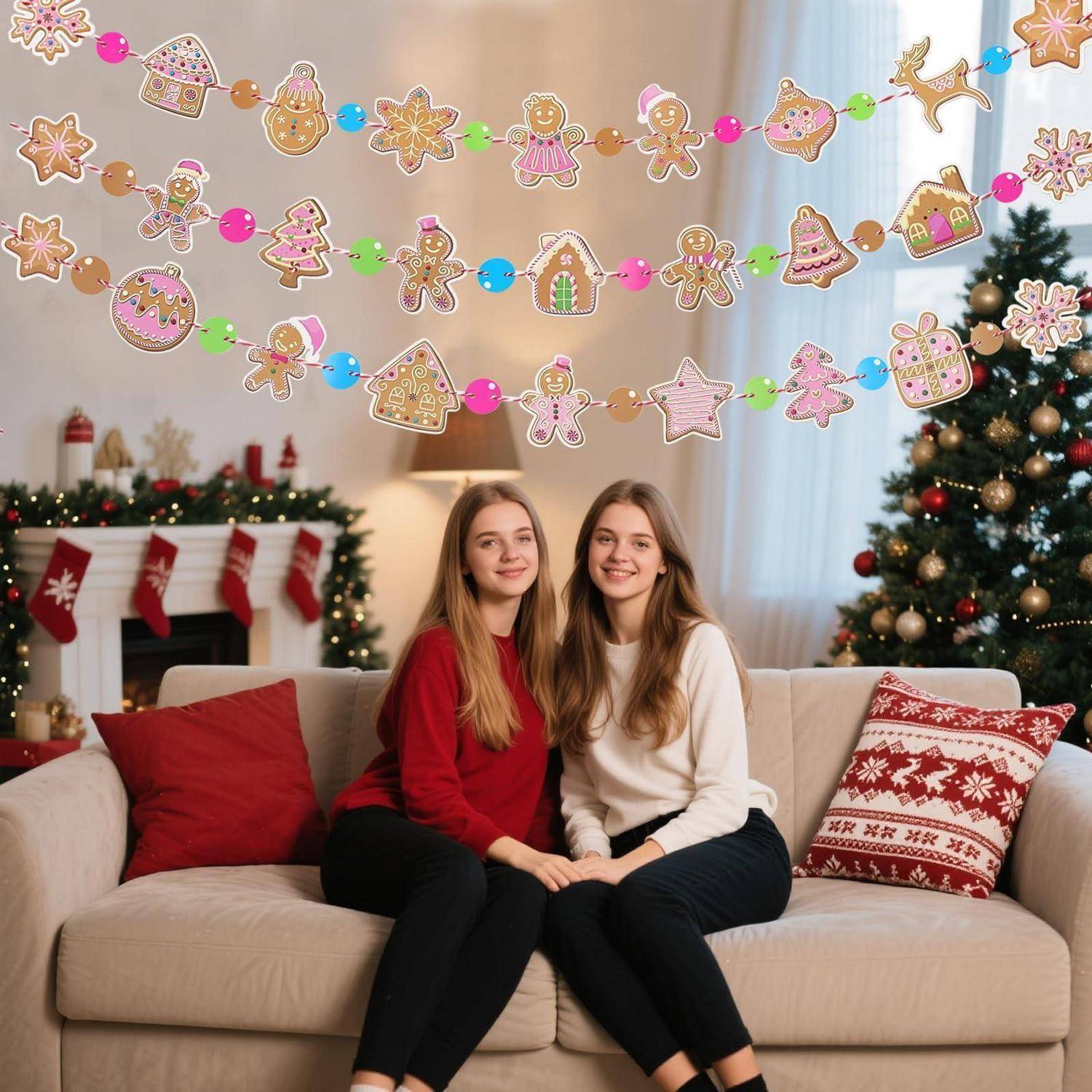 Zwei junge Frauen sitzen auf einem Sofa in einem geschmückten Wohnzimmer mit Weihnachtsgirlanden, Strümpfen und einem leuchtenden Baum.
