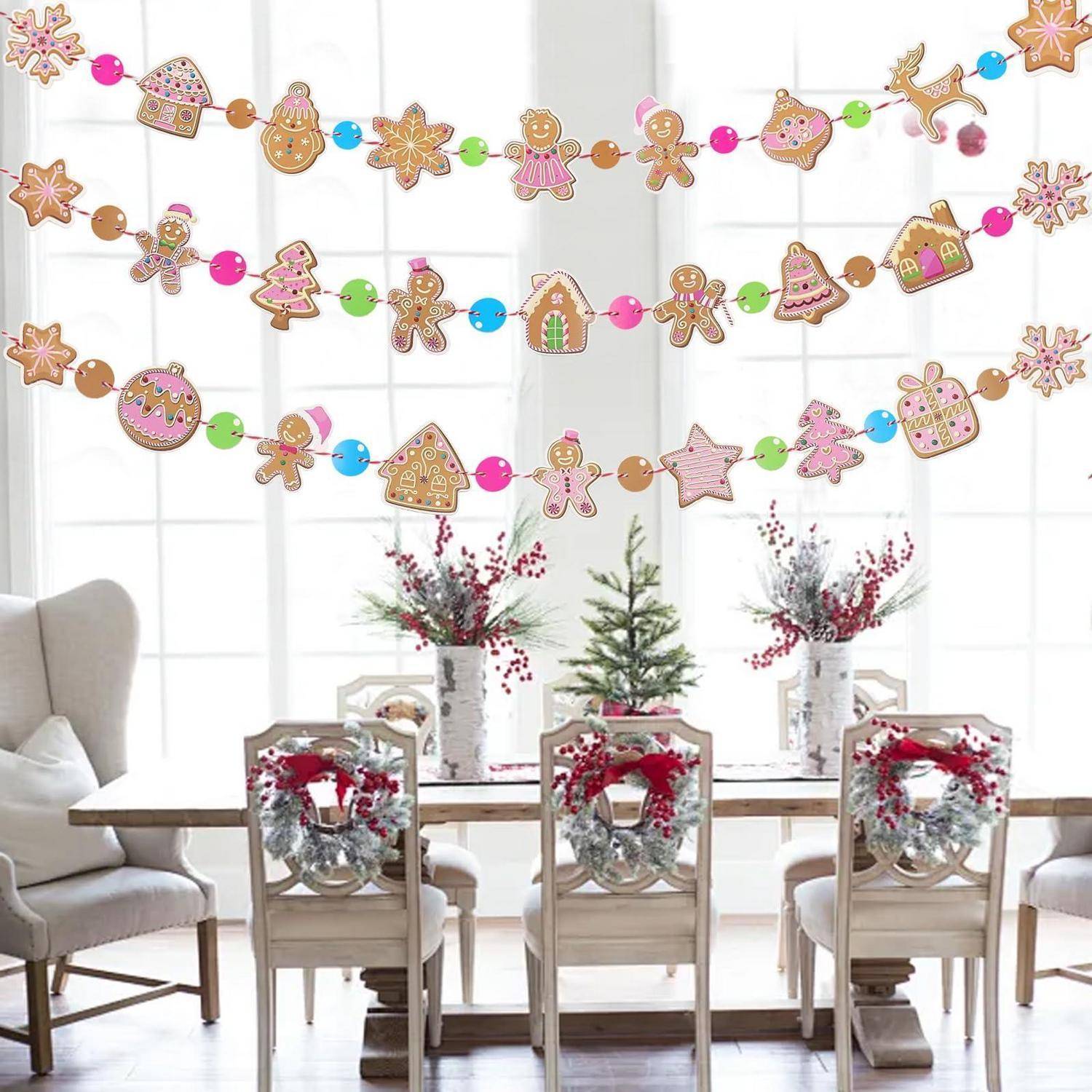 Festliches Esszimmer mit Lebkuchen-Keks-Girlande und Weihnachtskränzen auf Stühlen, angeordnet um einen Tisch mit weihnachtlichen Blumengestecken als Tischdekorationen.