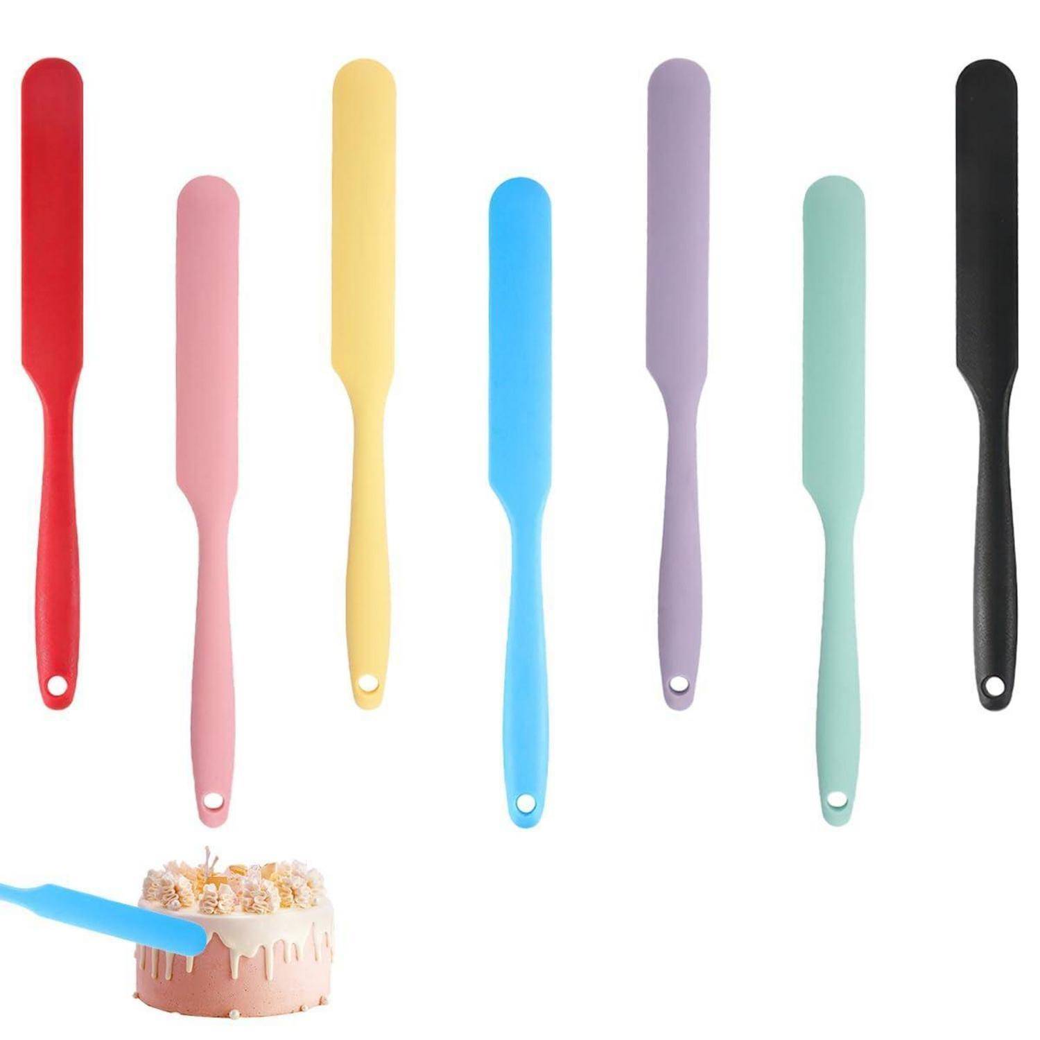 Set von sechs farbigen Zuckerguss-Spachteln auf weißem Hintergrund, wobei eine blaue Spachtel gezeigt wird, die Zuckerguss auf einen kleinen Kuchen aufträgt.