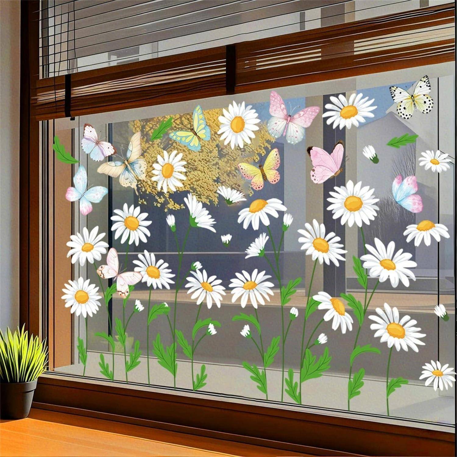 Fenster mit Gänseblümchen- und Schmetterlingsdekalen dekoriert, mit einer Topfpflanze auf der Fensterbank.