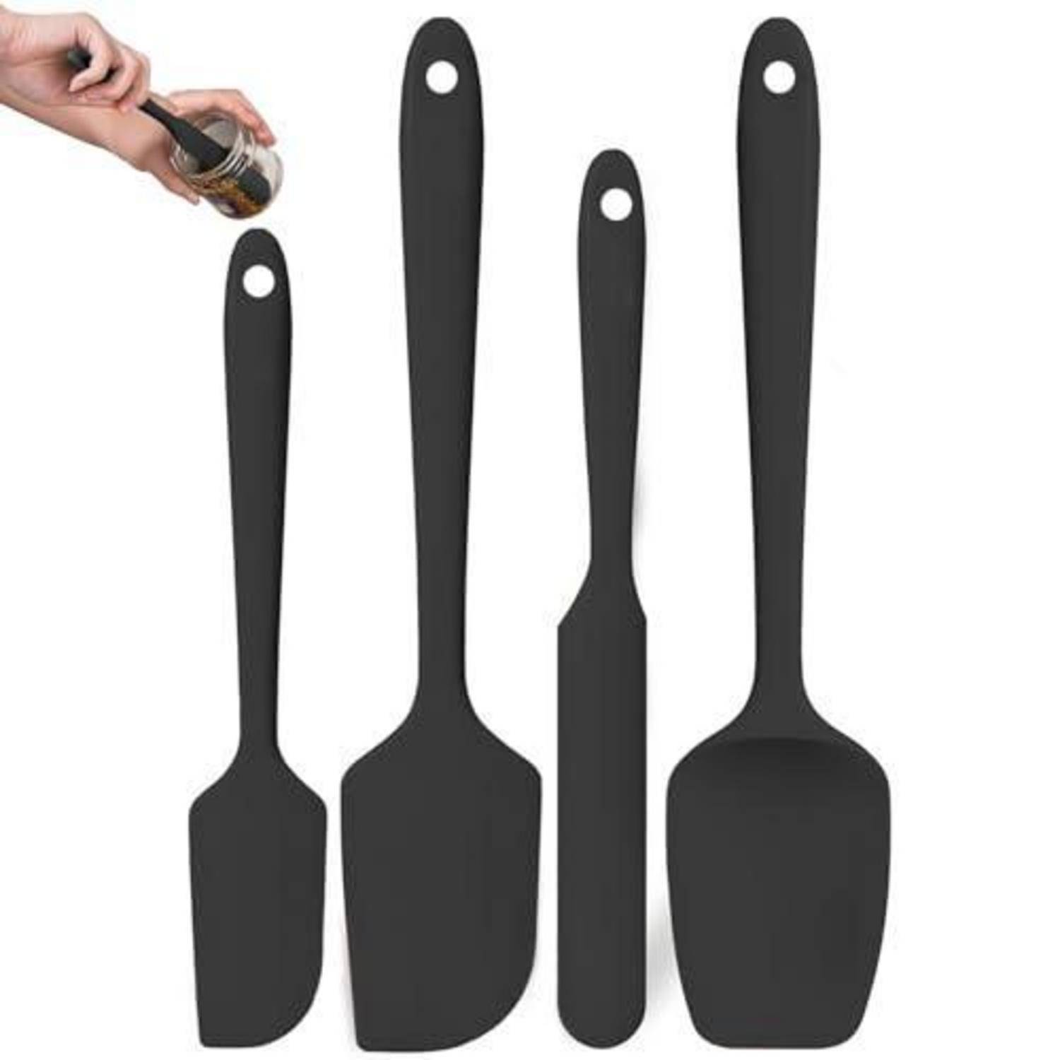 Satz aus vier schwarzen Silikon-Spachteln und Spachtelwerkzeugen, mit einer Hand, die Flüssigkeit auf die kleinste gießt.