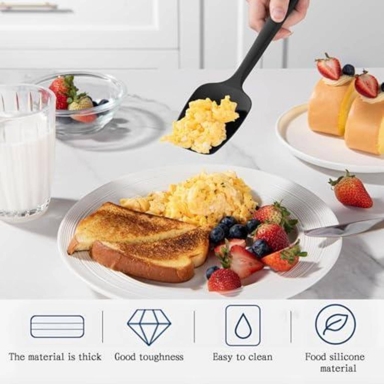 Frühstück auf einem weißen Teller serviert: Toast, Rührei und gemischte Beeren, mit einer Hand, die einen schwarzen Spatel benutzt; darunter angebrachte Symbole werben für dickes Material, gute Zähigkeit, einfache Reinigung und lebensmittelgeeignetes Silikon.
