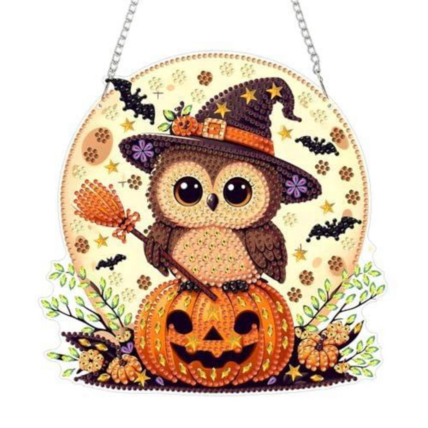 Eulendekoration zu Halloween mit Hexenhut, sitzend auf einem geschnitzten Kürbis, mit Fledermäusen und Herbstblättern, aufgehängt an Ketten.