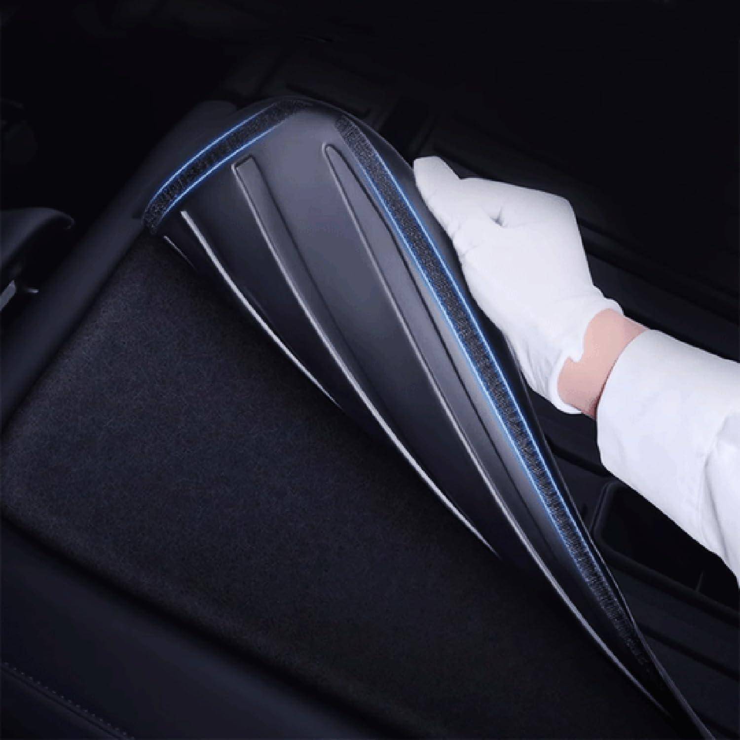 Behandschuhte Hand, die eine schwarze Autositzbezug oder ein Kissen mit blauer Naht hält, zeigt ein elegantes Automobil-Interieur-Zubehör.
