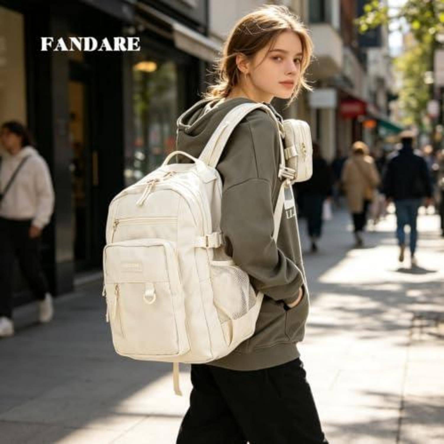 Junge Frau, die auf einer Stadtstraße mit einem großen cremefarbenen Rucksack spaziert und die FANDARE-Taschenlinie bewirbt.