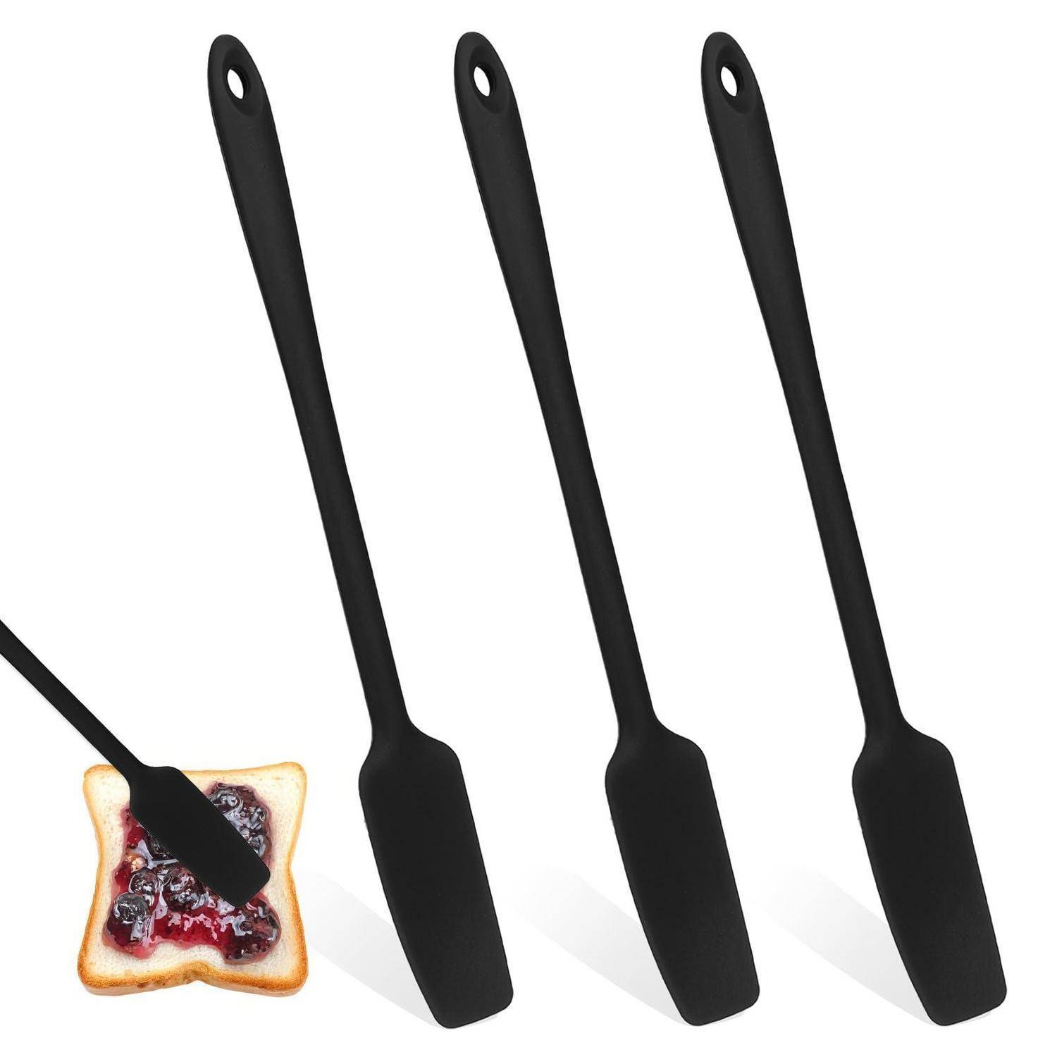 Drei schwarze Silikonspatel mit Aufhängelöchern; einer verteilt Marmelade auf einer Toastscheibe.