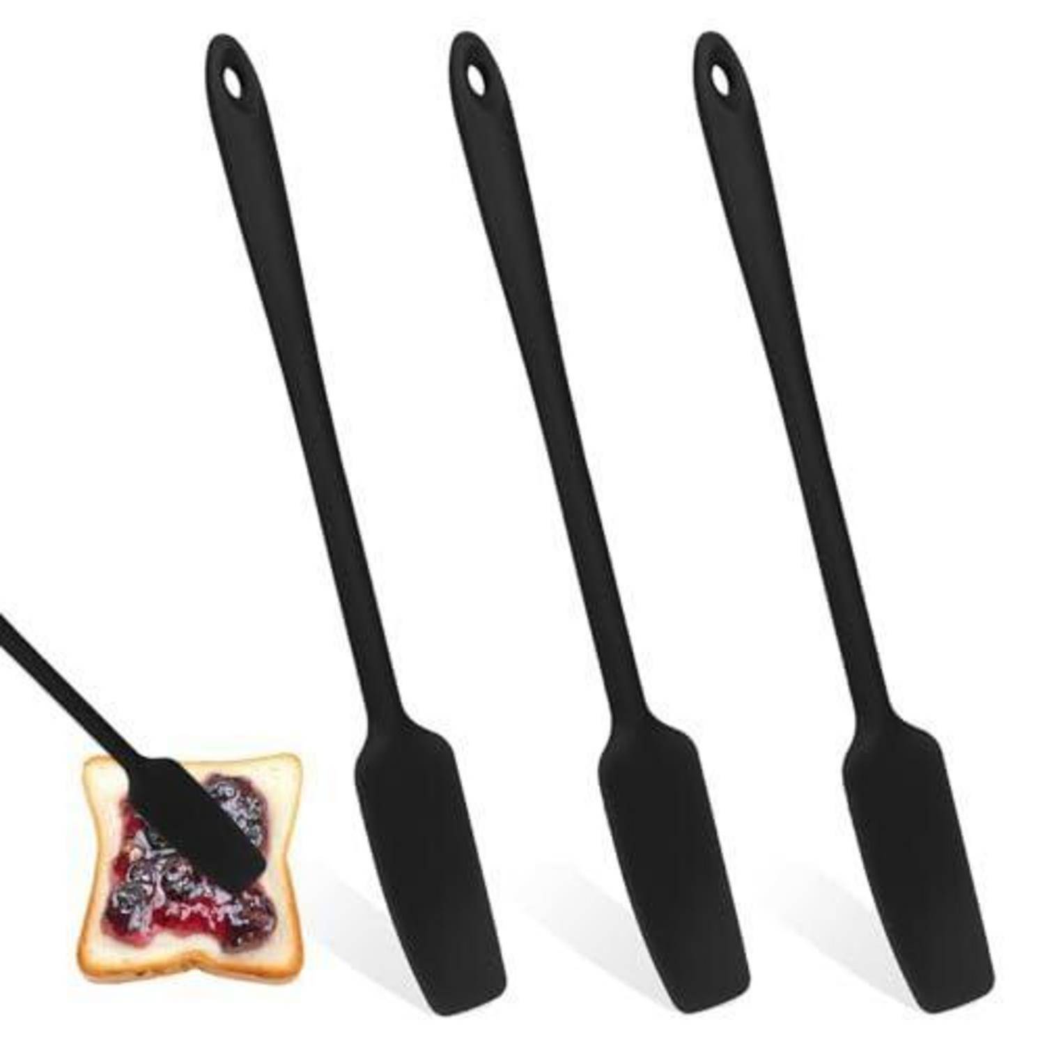 Drei schwarze Silikonspachteln mit Aufhängelöchern, neben einer Scheibe mit Marmelade bedecktem Toast abgebildet, um ihre Verwendung zu demonstrieren.