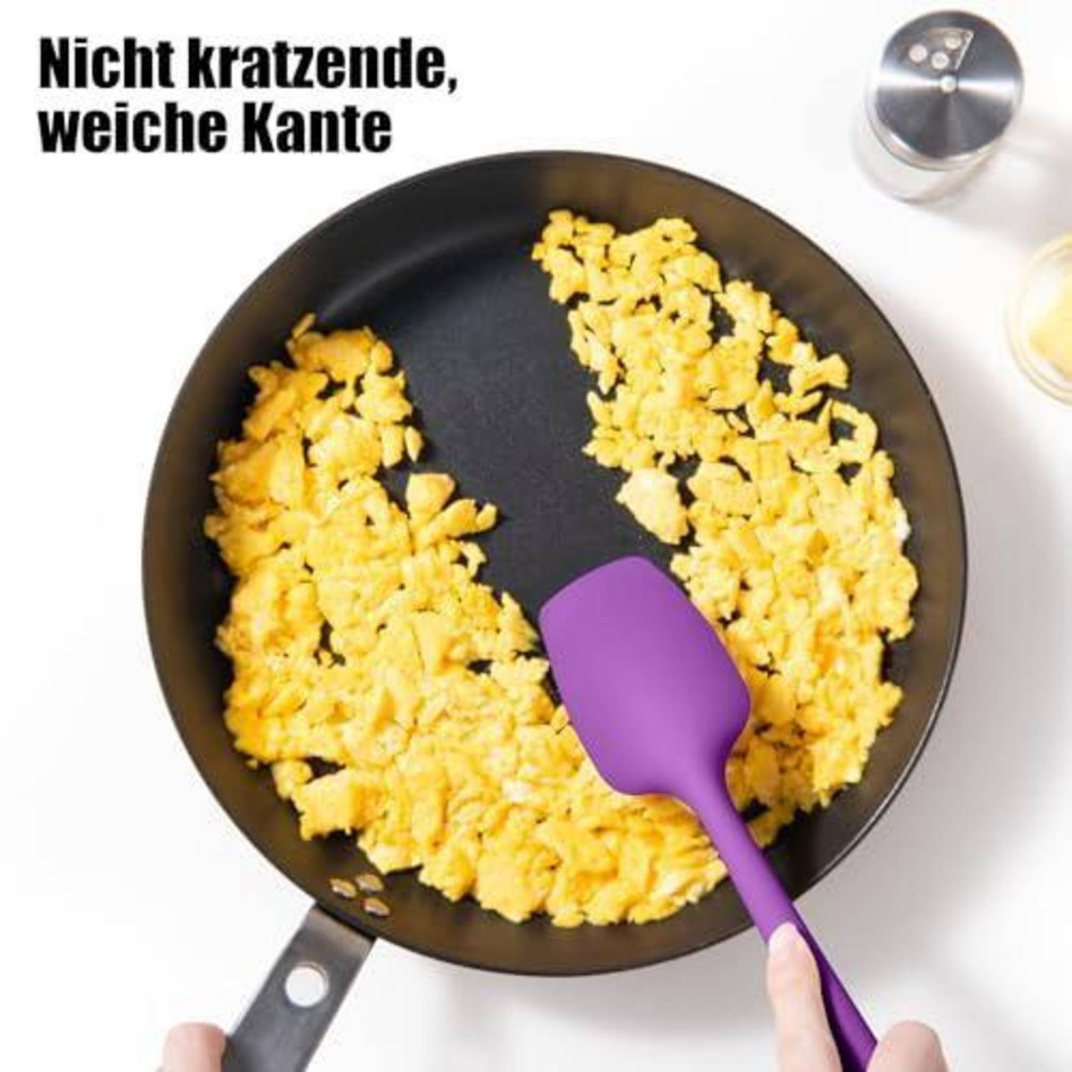 Spiegeleier in einer Pfanne mit einem lila Spatel und deutschem Text „Nicht kratzende, weiche Kante