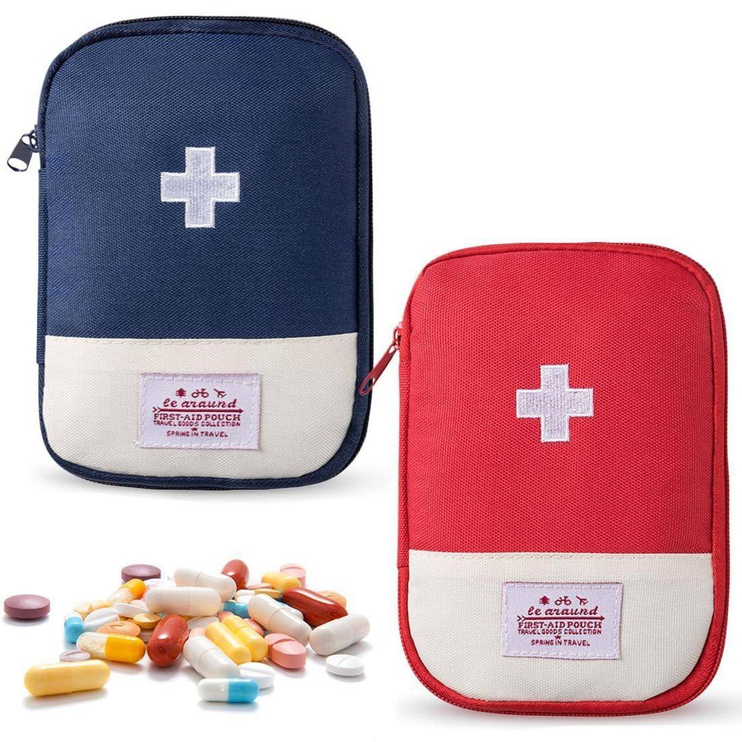 Zwei verschlossene Erste-Hilfe-Taschen, eine blau und eine rot, jeweils mit einem weißen Kreuz; bunte Pillen sind verstreut davor.