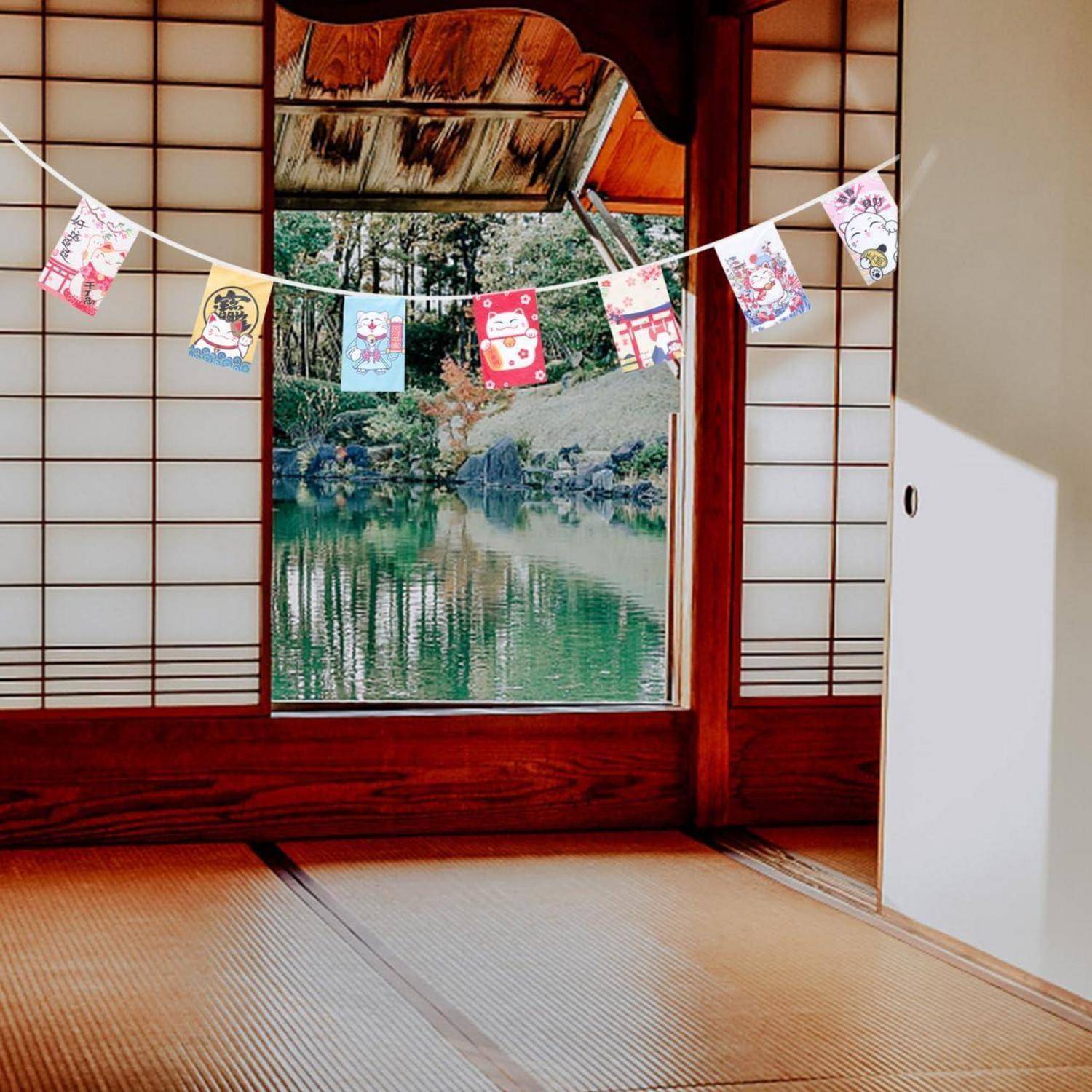 Tatami-Zimmer mit offener Shoji-Tür, die auf einen Teich blickt, mit einer Reihe von hängenden festlichen Karten über der Öffnung.