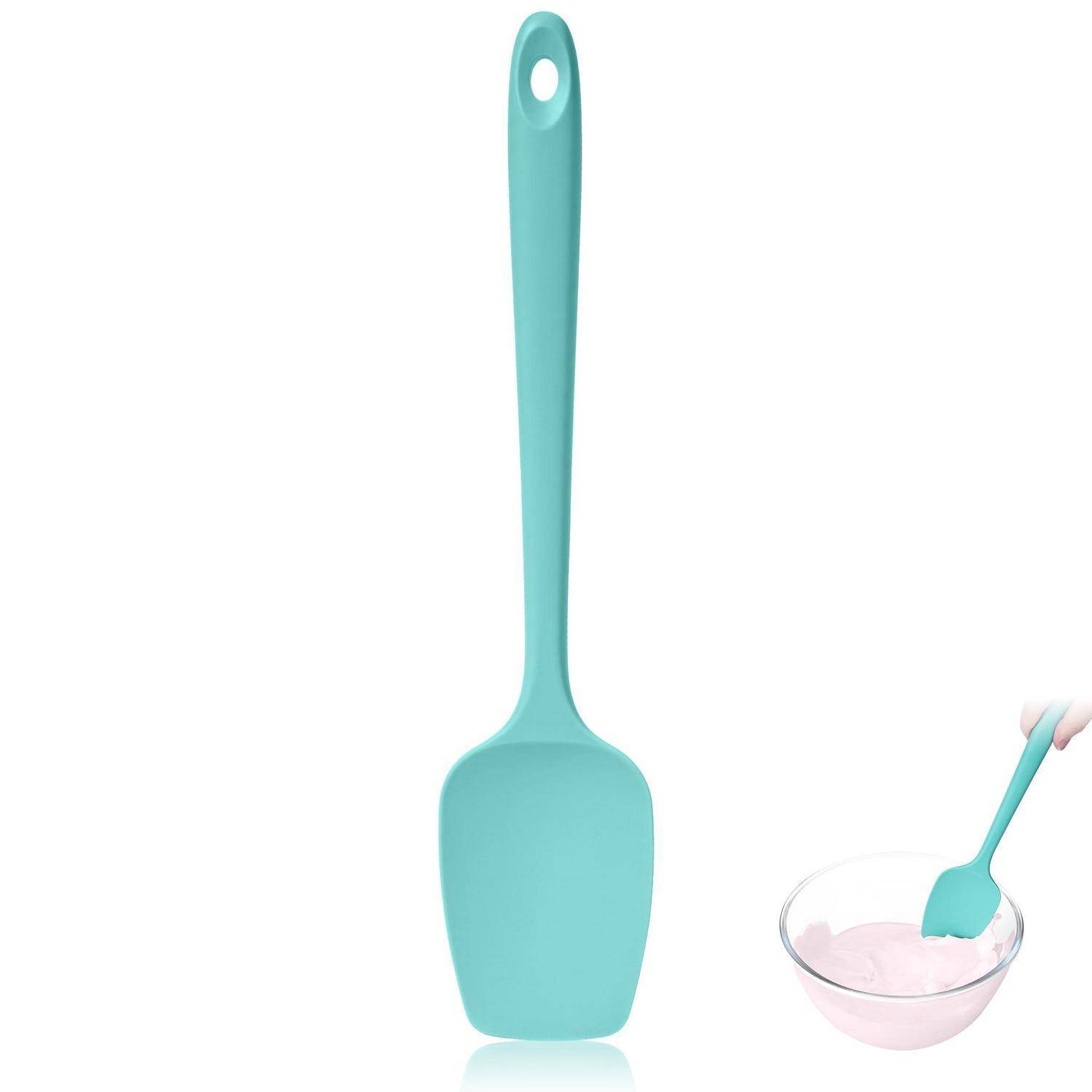 Türkisfarbener Silikonspatel aufrecht gezeigt, mit einem kleinen Ausschnitt, der ihn beim Umrühren von rosa Teig in einer Glasschüssel zeigt.