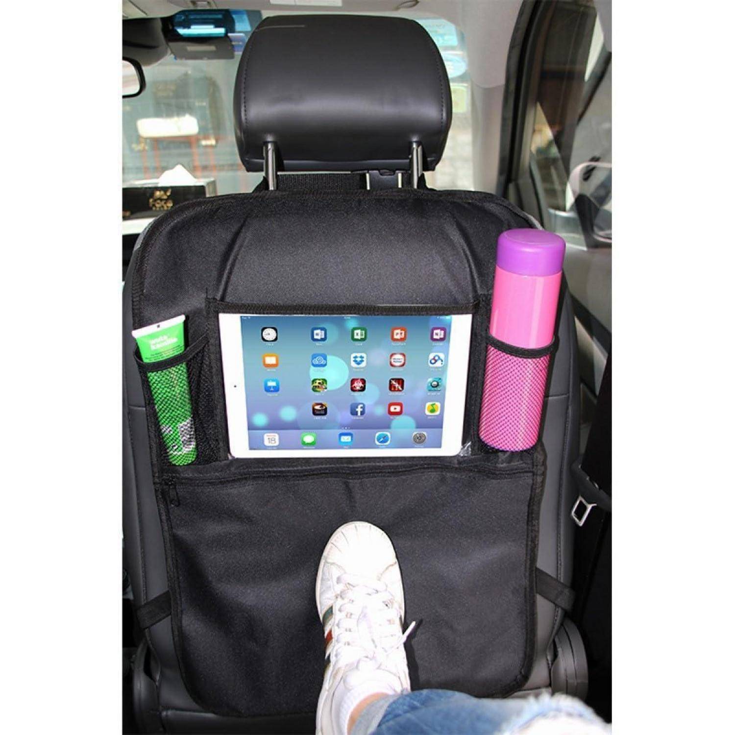 Tablet auf einer Autositzorganizer montiert, zwischen den Vordersitzen angebracht, mit seitlichen Netztaschen und einem sichtbaren Fuß eines Passagiers darunter.