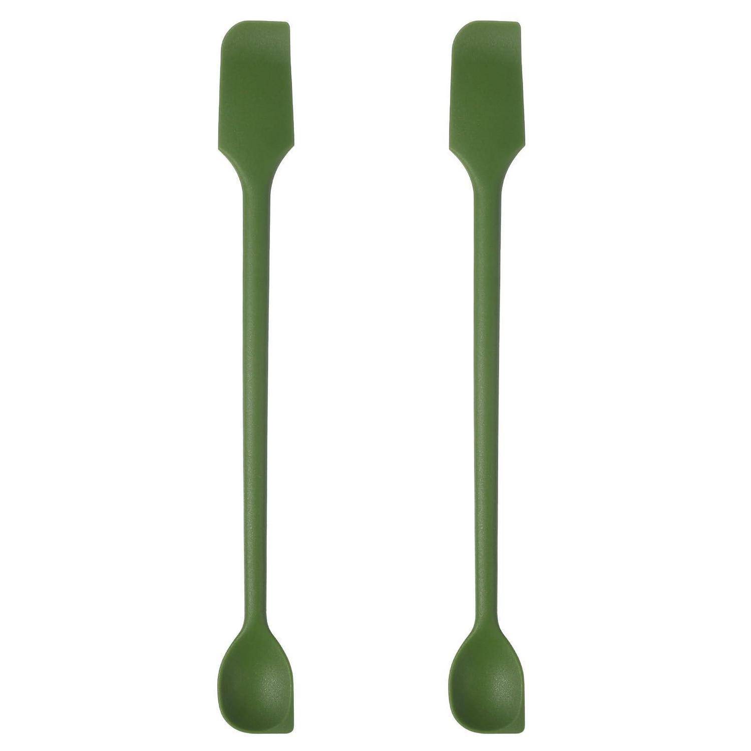 Zwei grüne Silikonspatel oder Rührtool nebeneinander auf einfachem weißem Hintergrund gezeigt.
