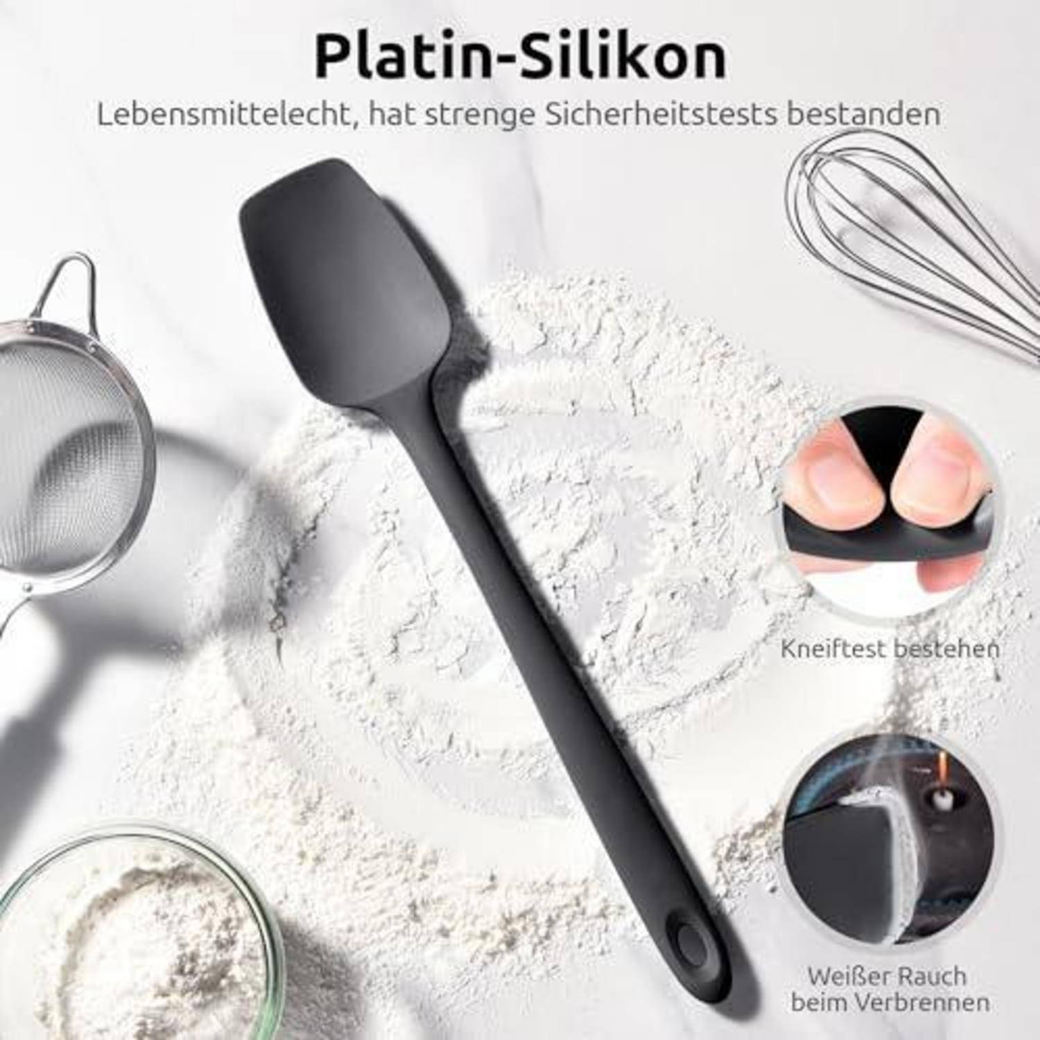 Schwarzer Silikonspatel auf Mehl mit Schneebesen und Sieb; deutscher Text besagt „Platin-Silikon