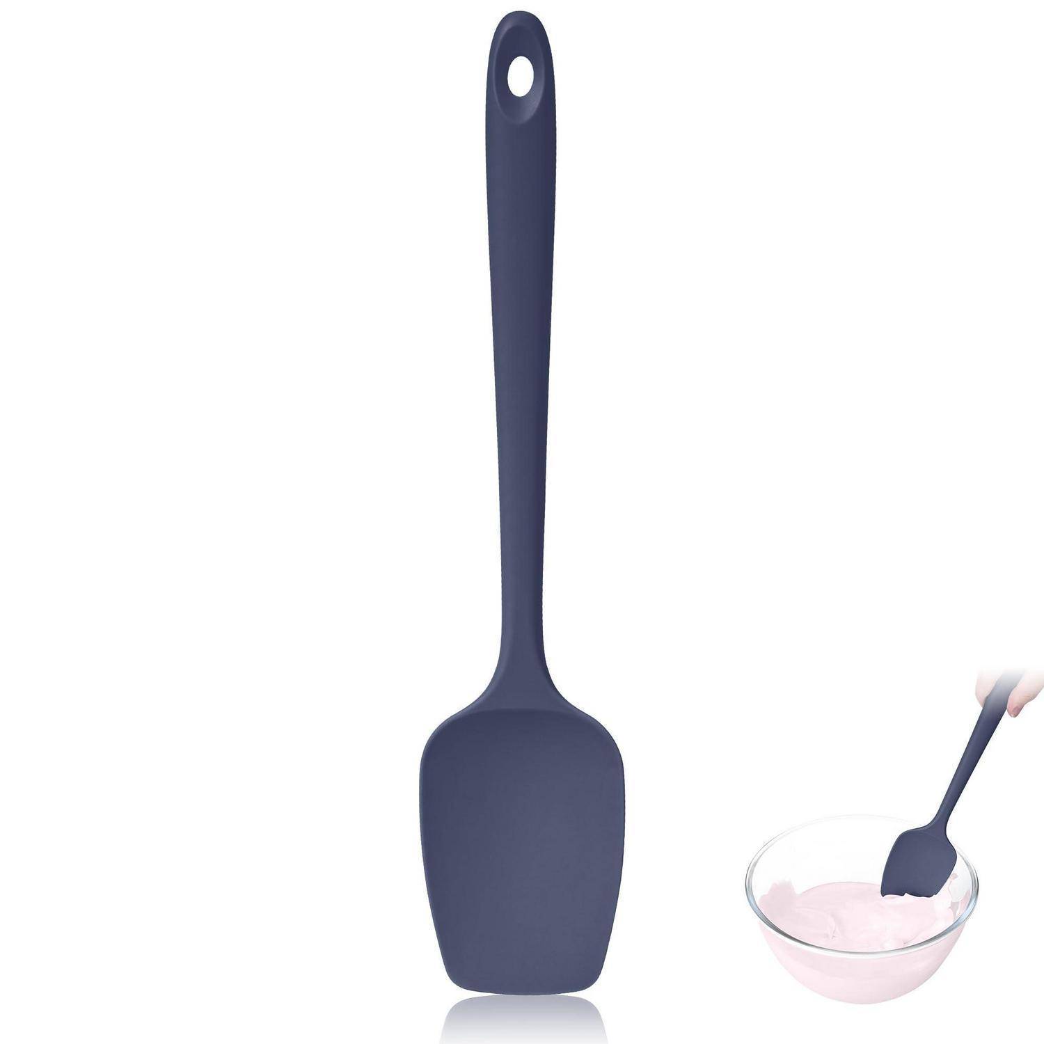 Dunkelblauen Silikonspatel mit Aufhängeloch, gezeigt mit einer kleinen Schüssel rosa Teig, der gerührt wird.