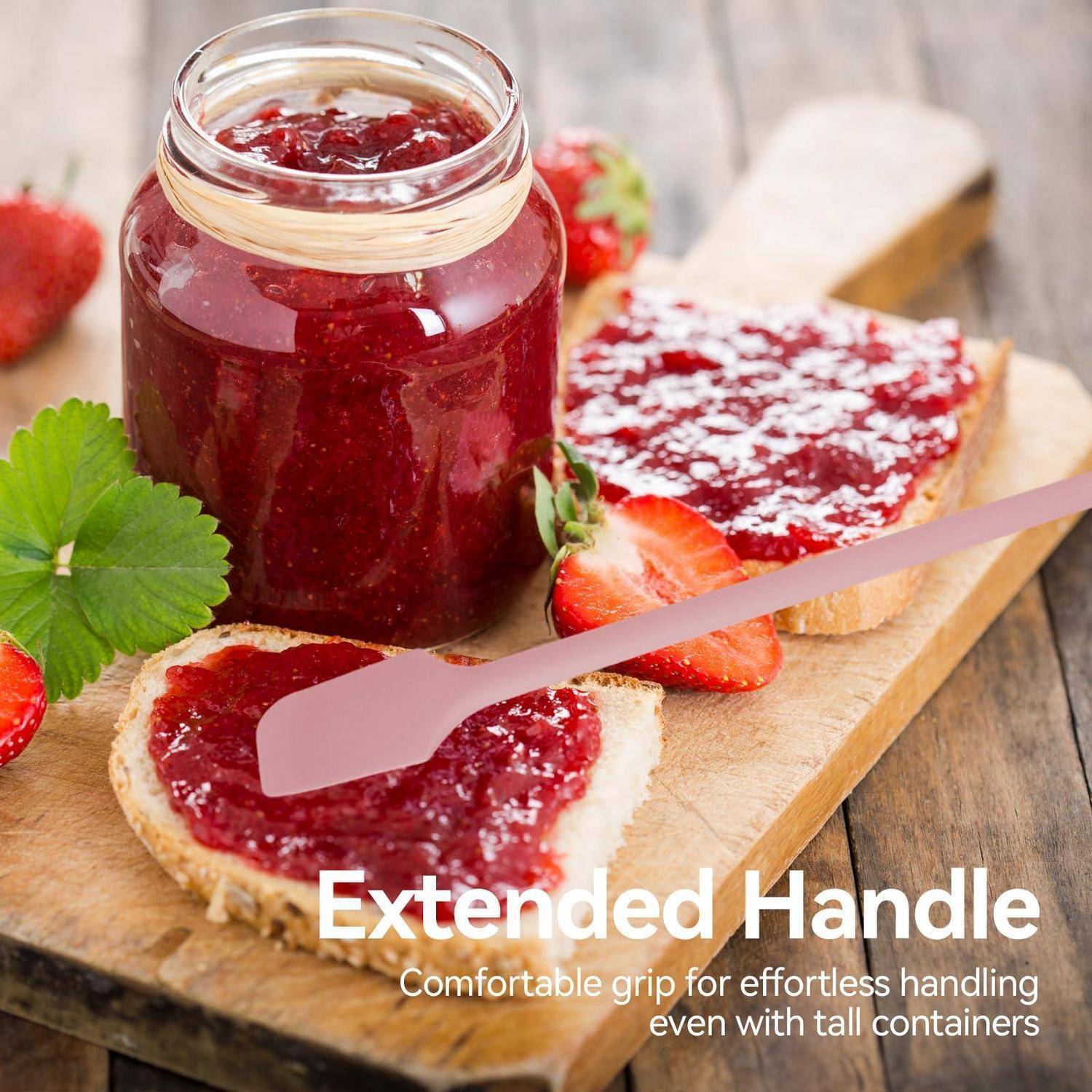 Glas mit Erdbeermarmelade und einem rosa Verstreicher mit verlängertem Griff auf Toast, beschriftet mit „Extended Handle