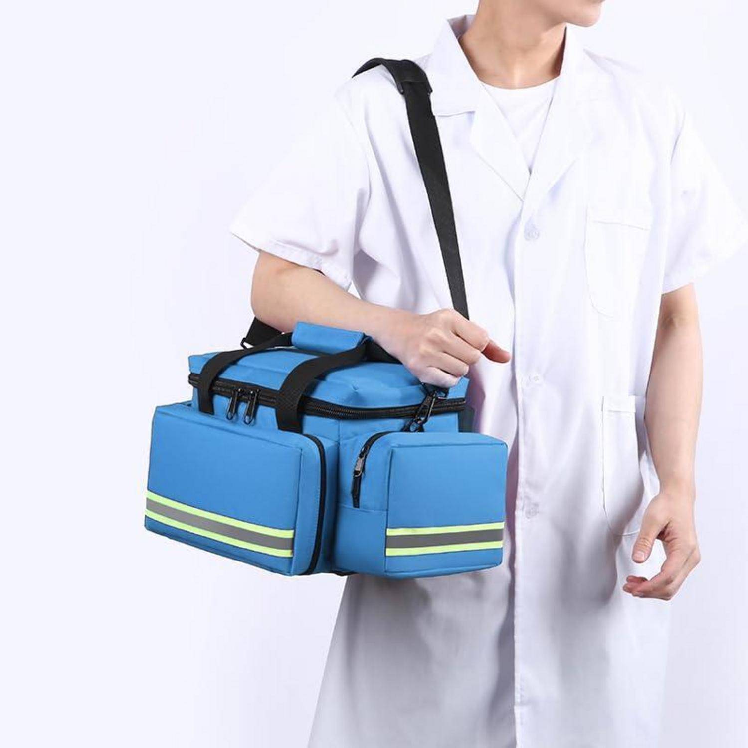Person in weißem Kittel, der eine blaue isolierte medizinische Kühlertasche mit Schultergurt trägt.