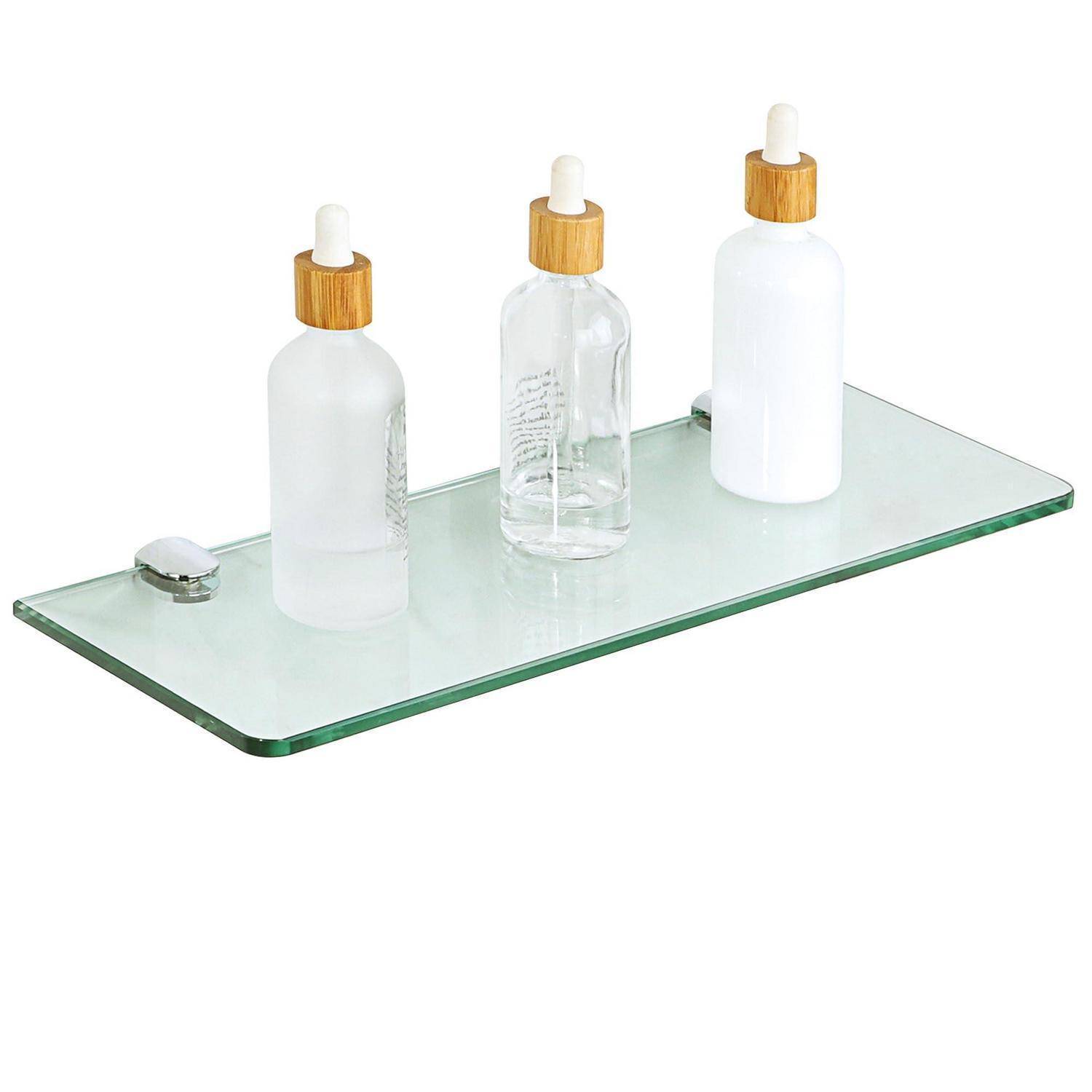 Drei kosmetische Tropferflaschen auf einem klaren Glasregal, mit einer transparenten Flasche und zwei mattweißen Flaschen.