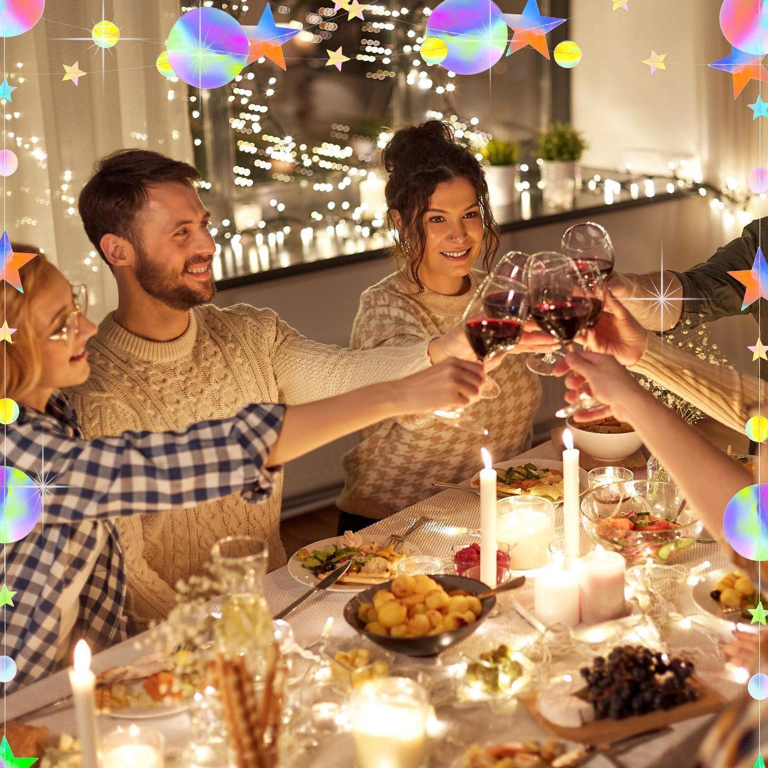 Freunde in gemütlichen Pullovern stoßen mit Rotwein um einen von Kerzenlicht erhellten Esstisch an, der mit Weihnachtslichtern und Speisen dekoriert ist.