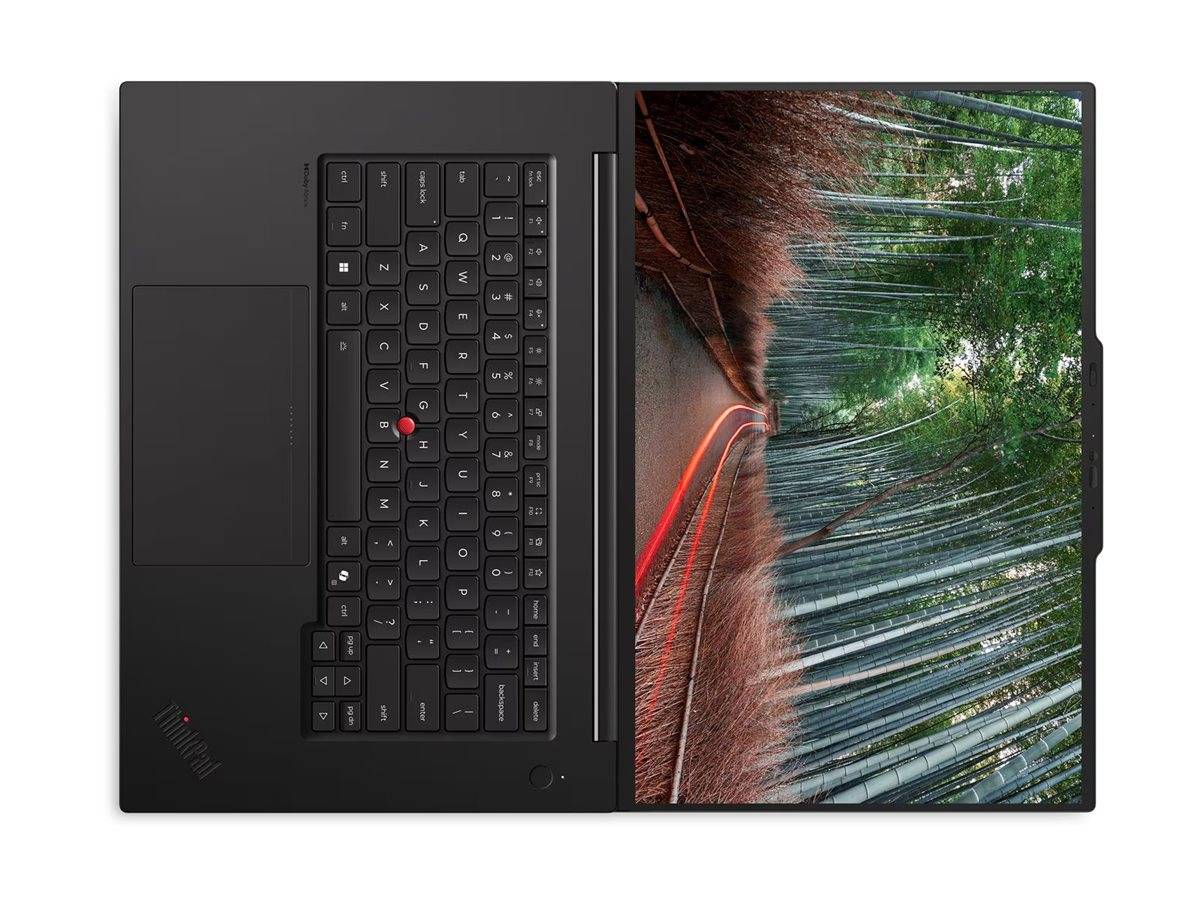 Draufsicht auf einen geöffneten Lenovo-Laptop mit Tastatur auf der linken Seite und Bildschirm, der eine Waldstraße mit roten Lichtstreifen anzeigt.