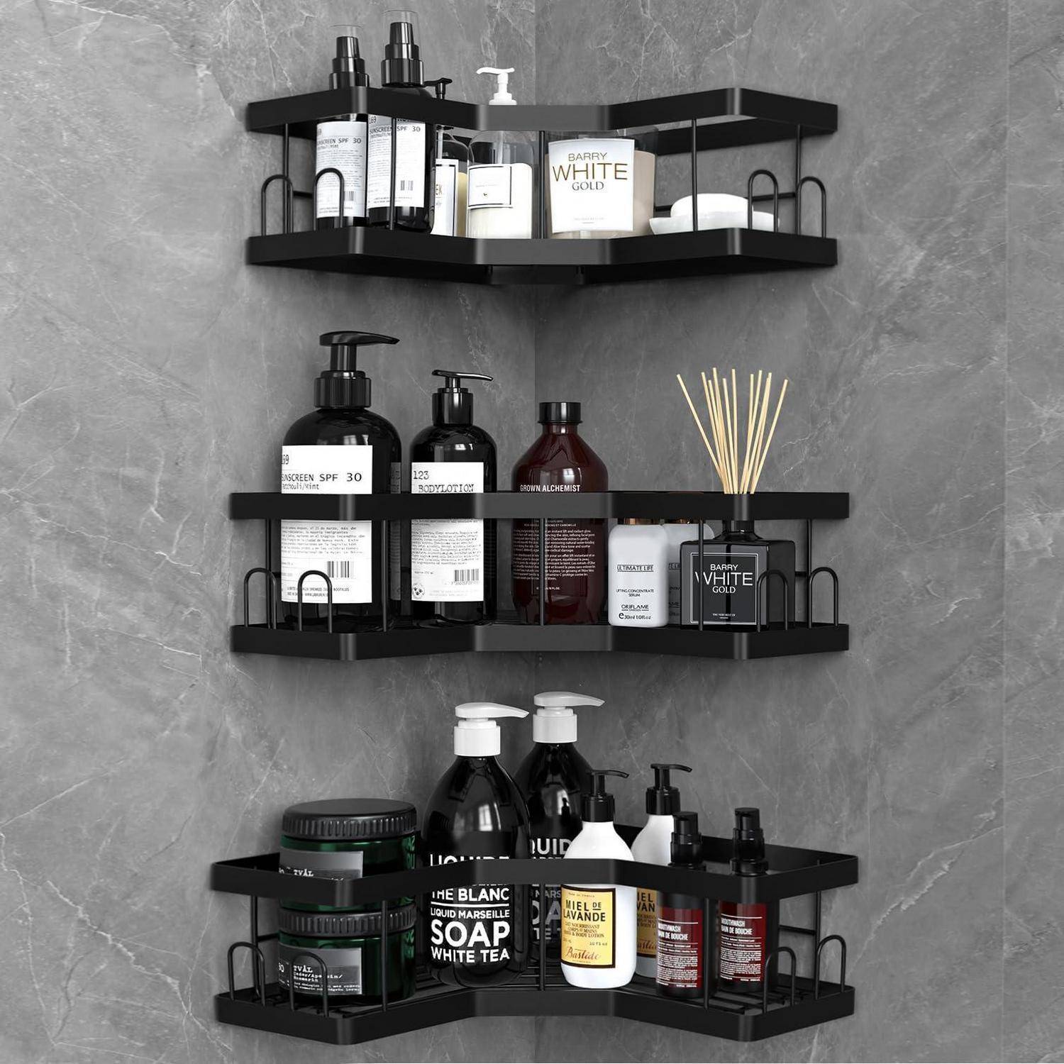 Drei schwarze Eckwandregale, die verschiedene Toilettenartikel, Seifenflaschen, Gläser und einen Raumduft-Diffuser gegen eine grau geflieste Wand halten.