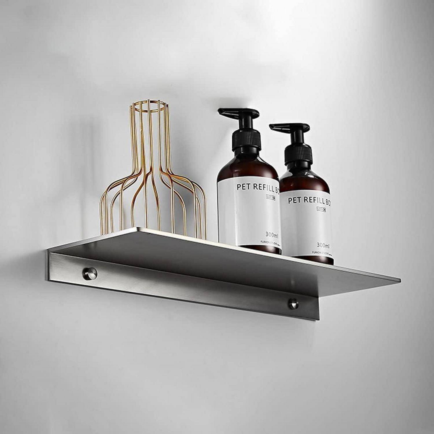 Schwebendes Metallwandregal mit zwei "PET REFILL""-Pumpflaschen und einer goldenen Drahtblumenvase vor einer hellen Wand.
