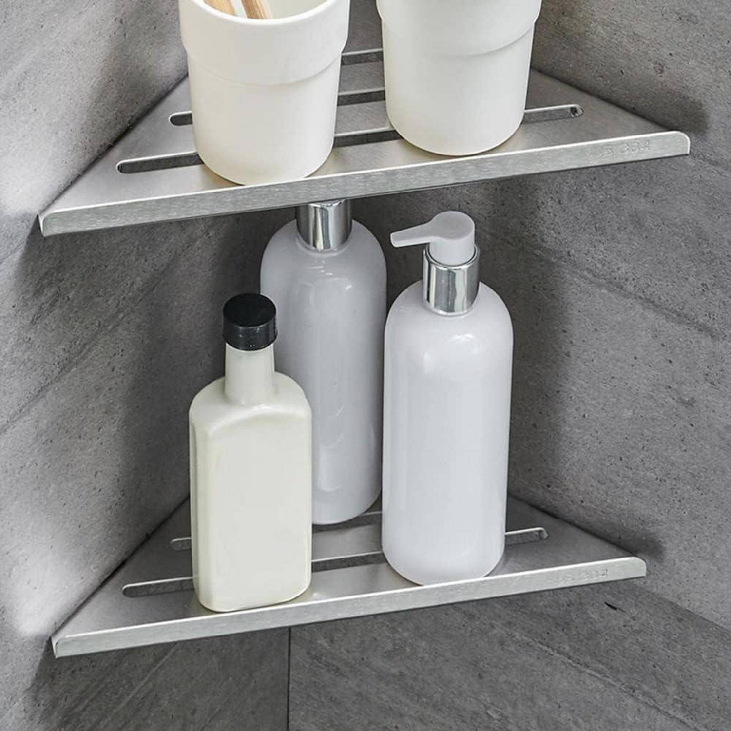 Eckregal einer Dusche, auf dem mehrere weiße Shampoo- und Seifenflaschen in einer gefliesten Badezimmerecke stehen.
