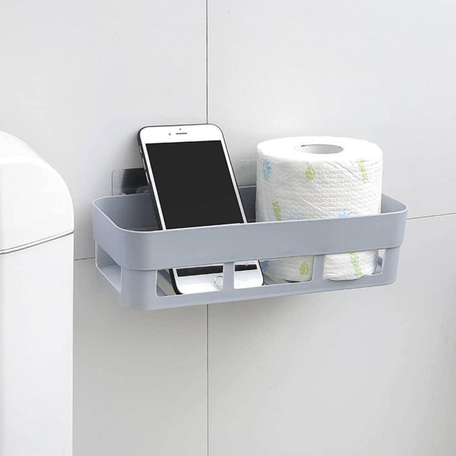 An der Wand montierter grauer Aufbewahrungskorb, der ein Smartphone und eine Rolle Toilettenpapier neben einer Toilette im Badezimmer hält.