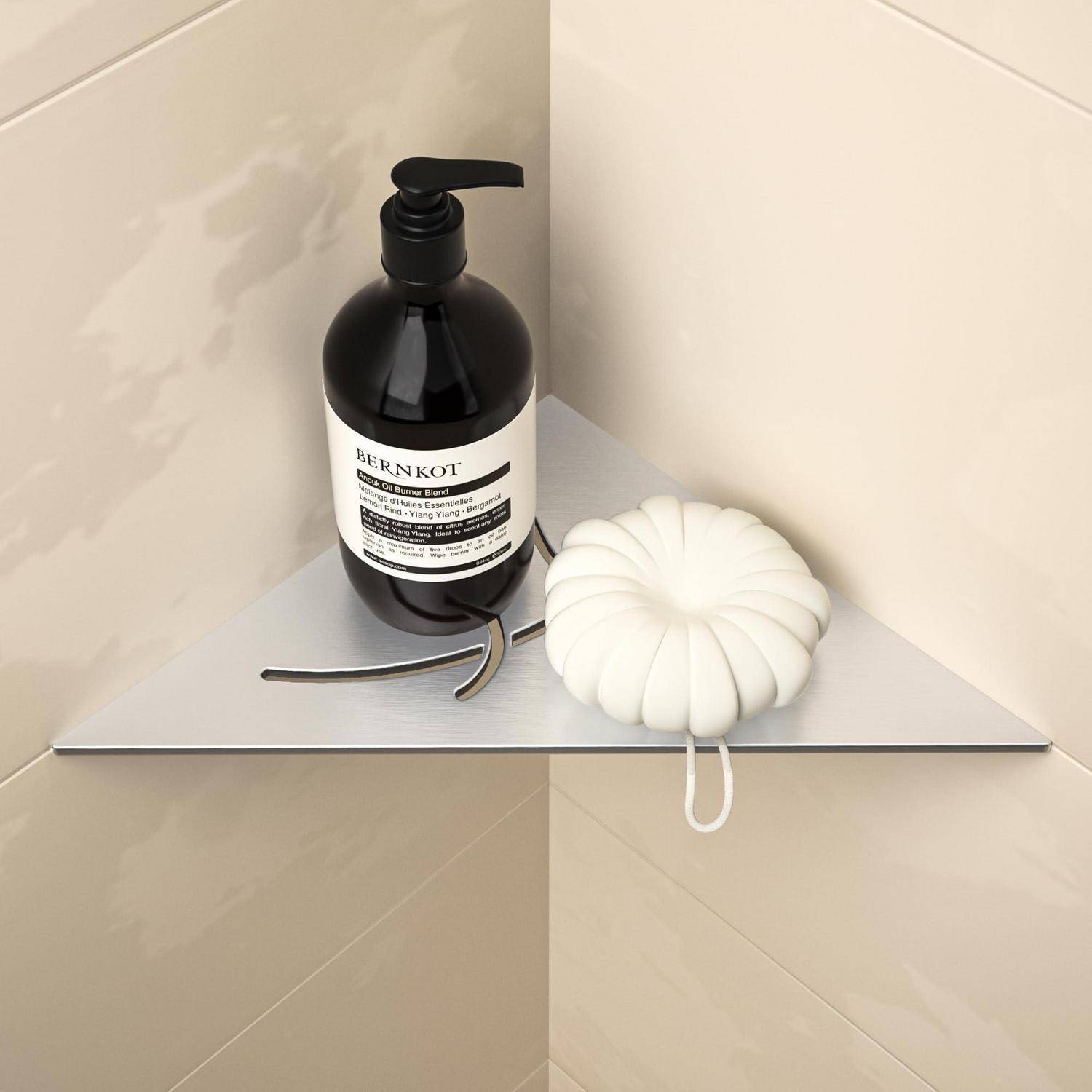 Schwarze Pumpflasche und weiße Silikonbürste auf einem dreieckigen Duscheckenregal im Badezimmer.