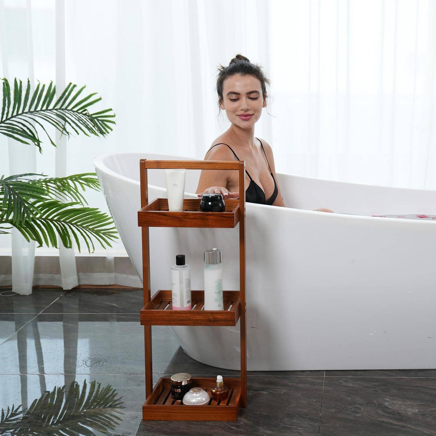 Frau, die sich in einer weißen Badewanne entspannt, neben einem hölzernen Badewannenbrett, das Toilettenartikel hält, mit einer Topfpflanze in der Nähe.